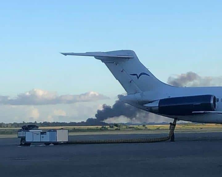 Una columna de humo se levanta en en la zona boscosa cercana al aeropuerto de Las Américas, lugar del siniestro de la aeronave en la que perdieron la vida 9 personas.