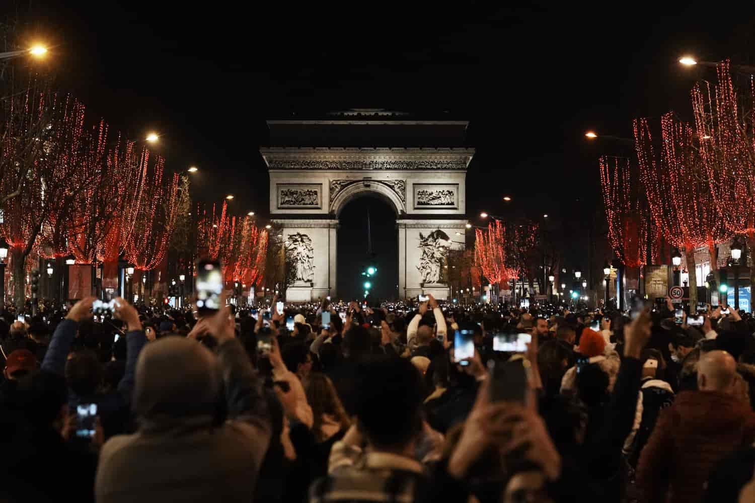 La gente celebra la víspera de Año Nuevo en la avenida de los Campos Elíseos, en París, el viernes 31 de diciembre de 2021.