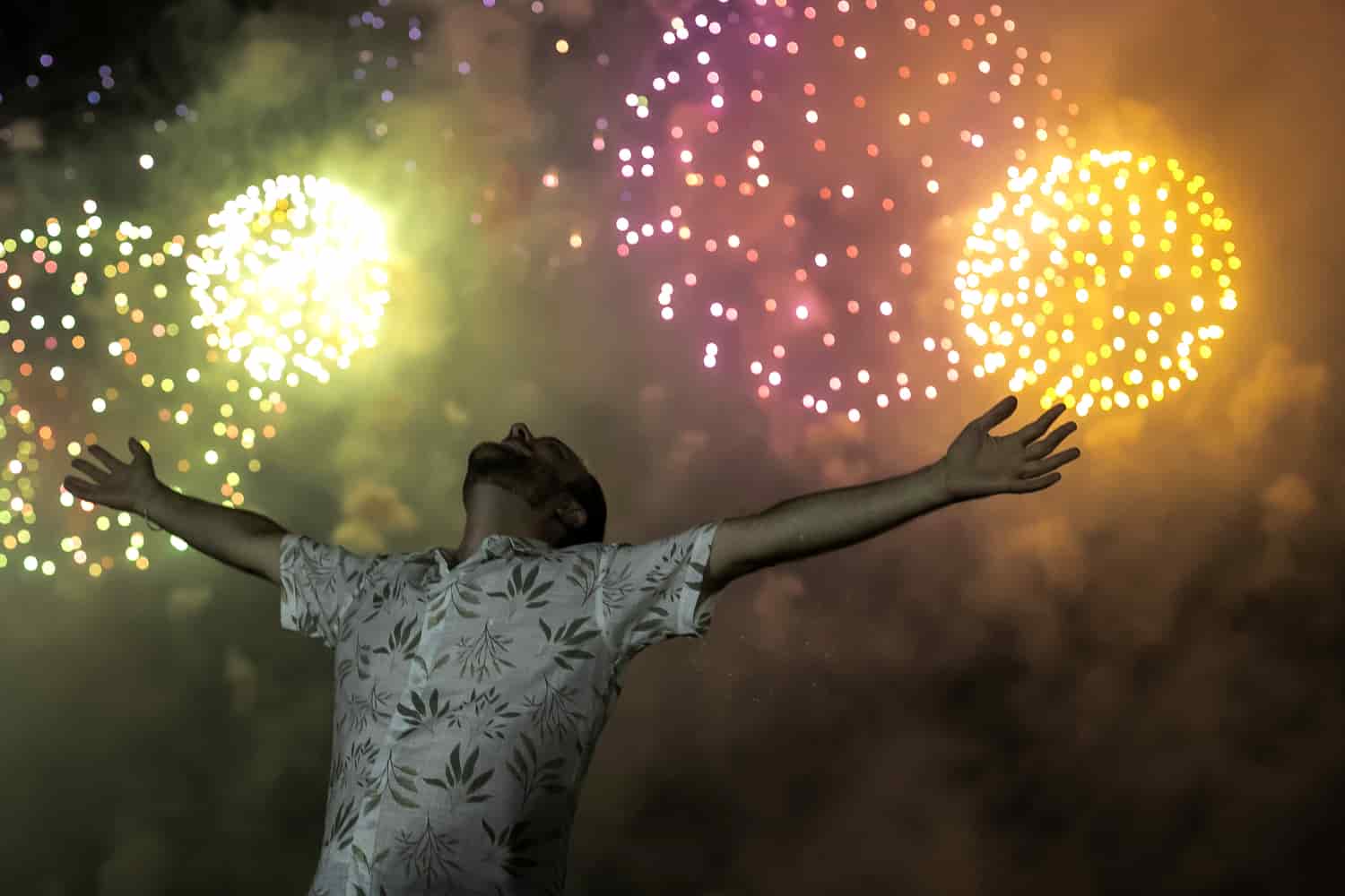 Un hombre celebra el comienzo del Año Nuevo, con el telón de fondo de los fuegos artificiales que explotan en la playa de Copacabana en Río de Janeiro, Brasil, el sábado 1 de enero de 2022.