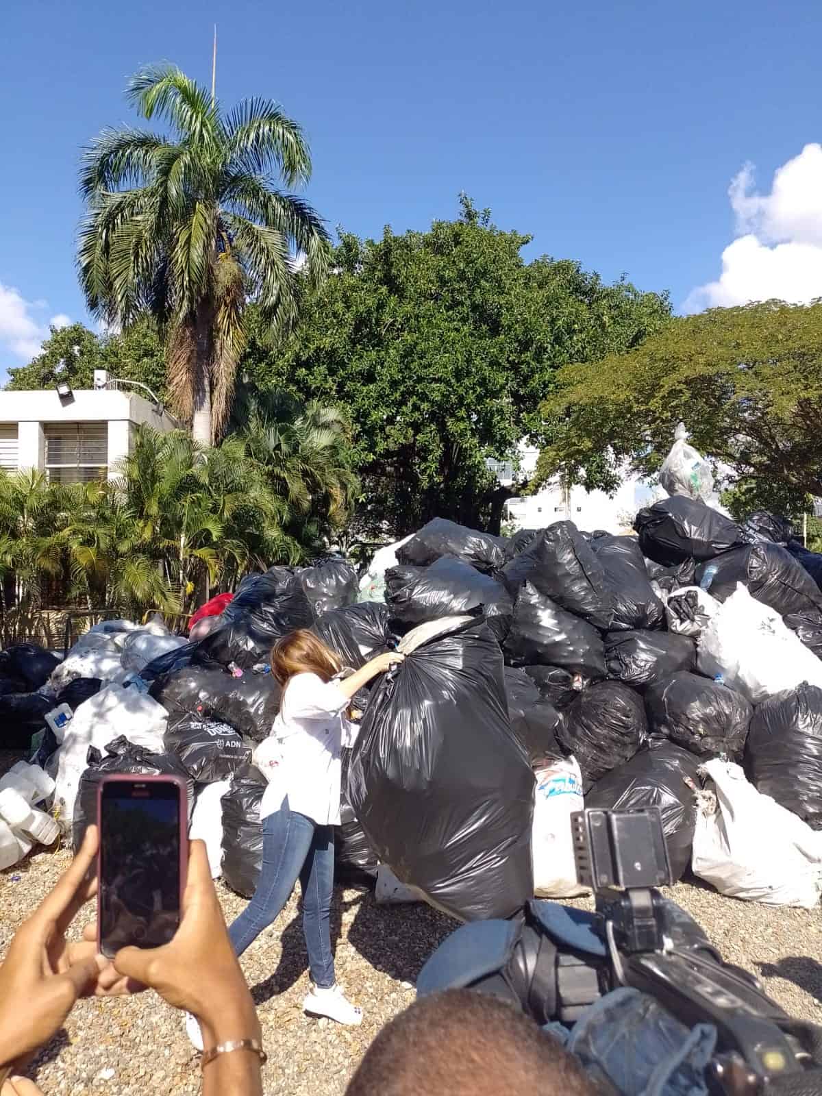 Carolina Mejía junto a varias fundas de botellas recolectadas 