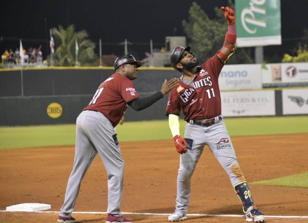 Marcell Ozuna simula un selfies con el coach de tercera, en su jonrón en la tercera entrada.