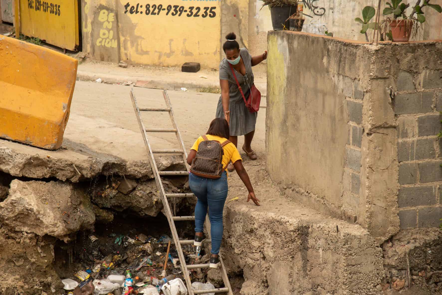 Una joven trata de cruzar por la cañada