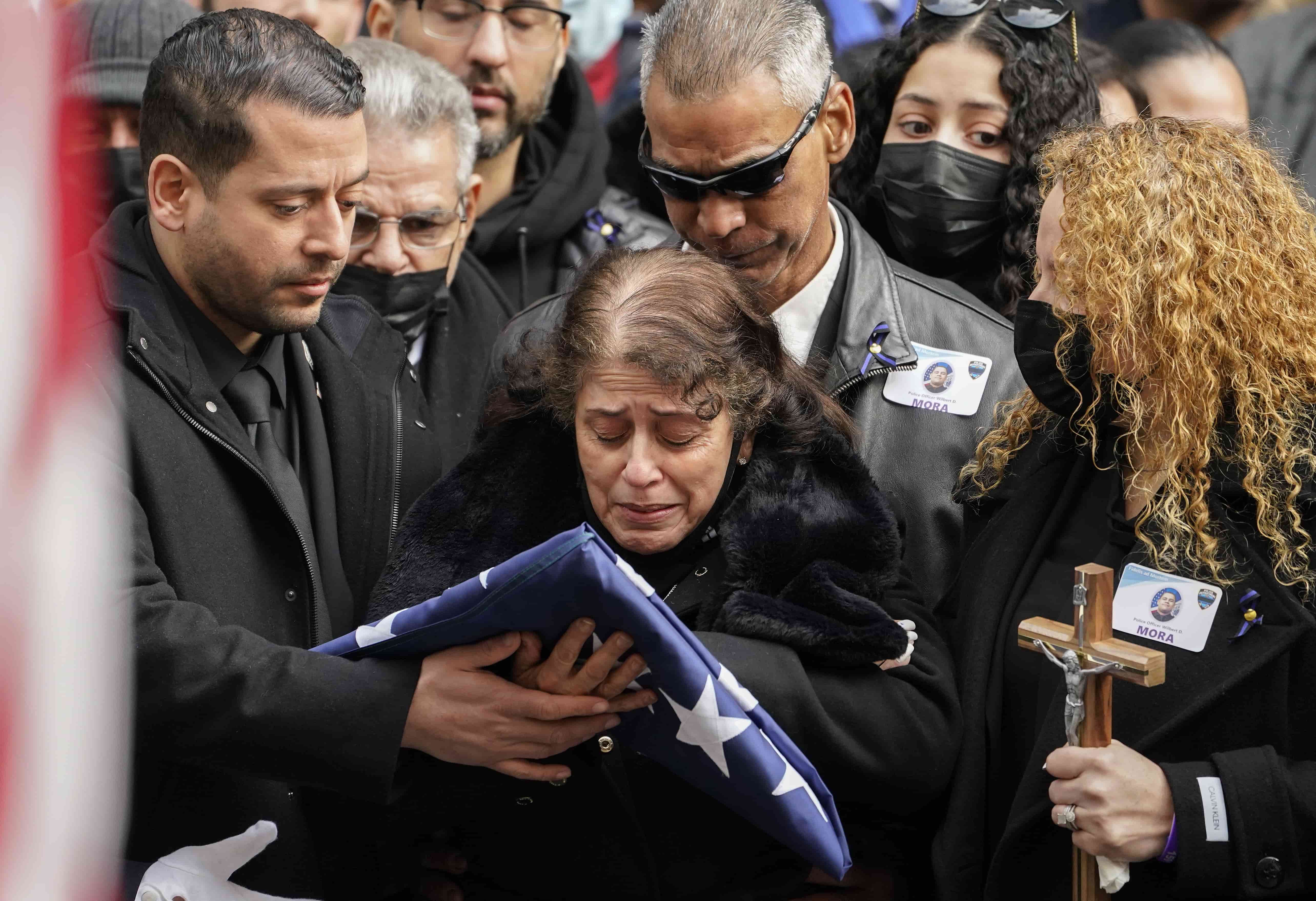Los familiares del oficial de policía de Nueva York, Wilbert Mora, reaccionan después del funeral de Mora en la Catedral de San Patricio, el miércoles 2 de febrero de 2022, en Nueva York.