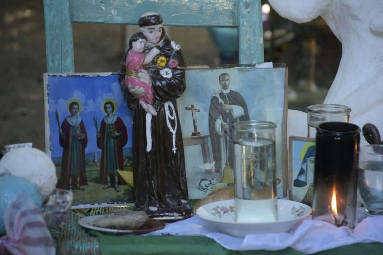 Velones encendidos al santo Martín de Porres (I) y a Martín de Porres.