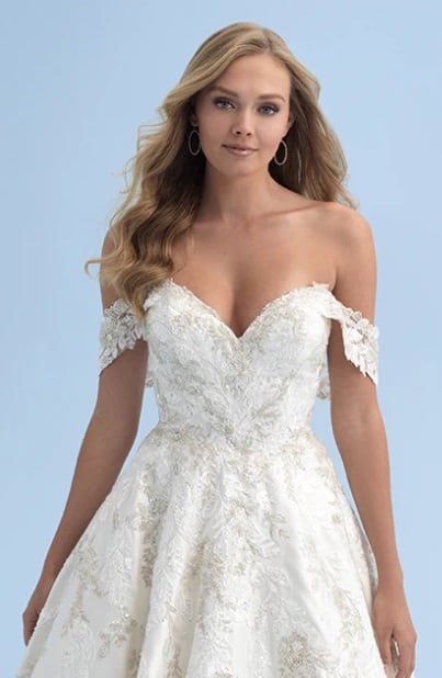 Vestido Cinderella. Los apliques superpuestos de cuentas y lentejuelas cubren el corpiño y la cola del elegante vestido de satén inspirado en Cenicienta. El escote corazón presenta una manga drapeada adjunta para darle un toque de elegancia atemporal.
