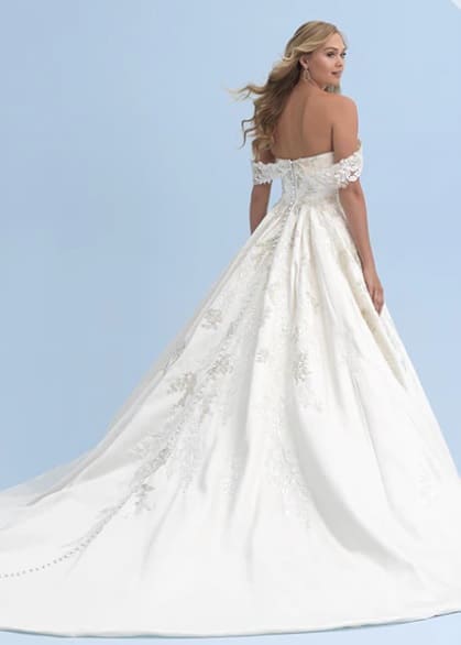 Vestido Cinderella. Los apliques superpuestos de cuentas y lentejuelas cubren el corpiño y la cola del elegante vestido de satén inspirado en Cenicienta. El escote corazón presenta una manga drapeada adjunta para darle un toque de elegancia atemporal.
