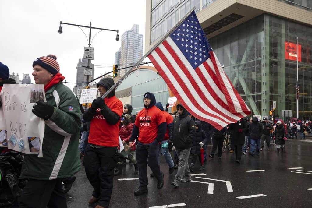 La gente marcha al puente de Brooklyn durante una protesta contra el mandato de vacunas antes de la posible terminación de los empleados de la ciudad de Nueva York debido a su estado de vacunación, el lunes 7 de febrero de 2022, en Nueva York.