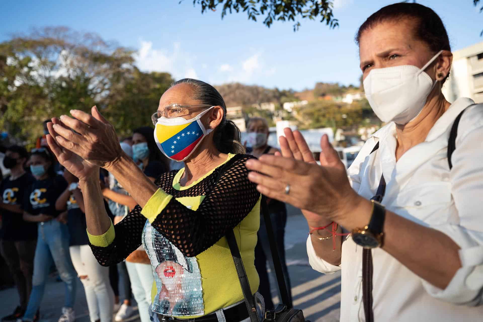 Dos mujeres aplauden durante una asamblea opositora denominada salvemos Venezuela, hoy, en Caracas (Venezuela).