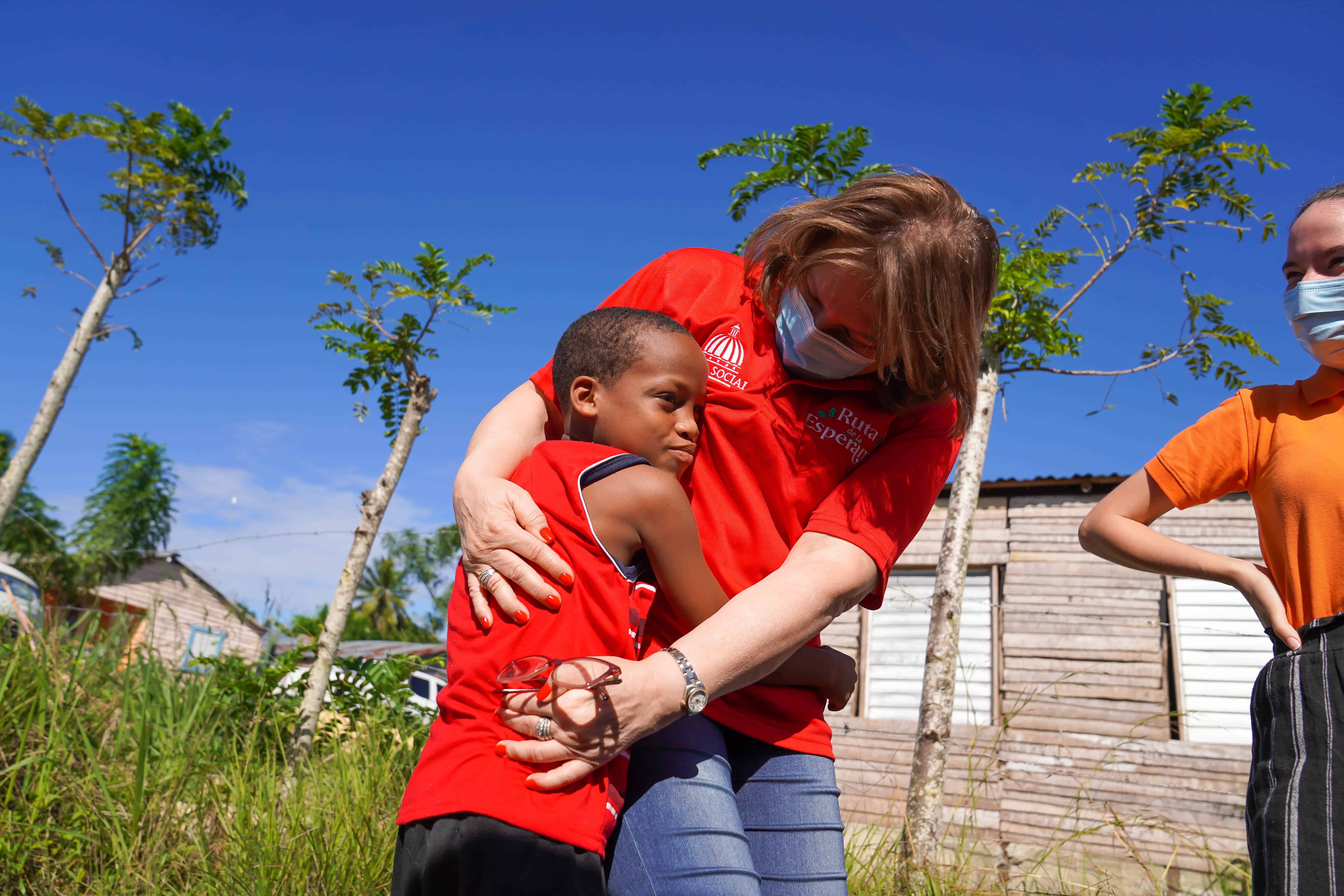 La directora de la institución, Yadira Henríquez, abrazando a un niño