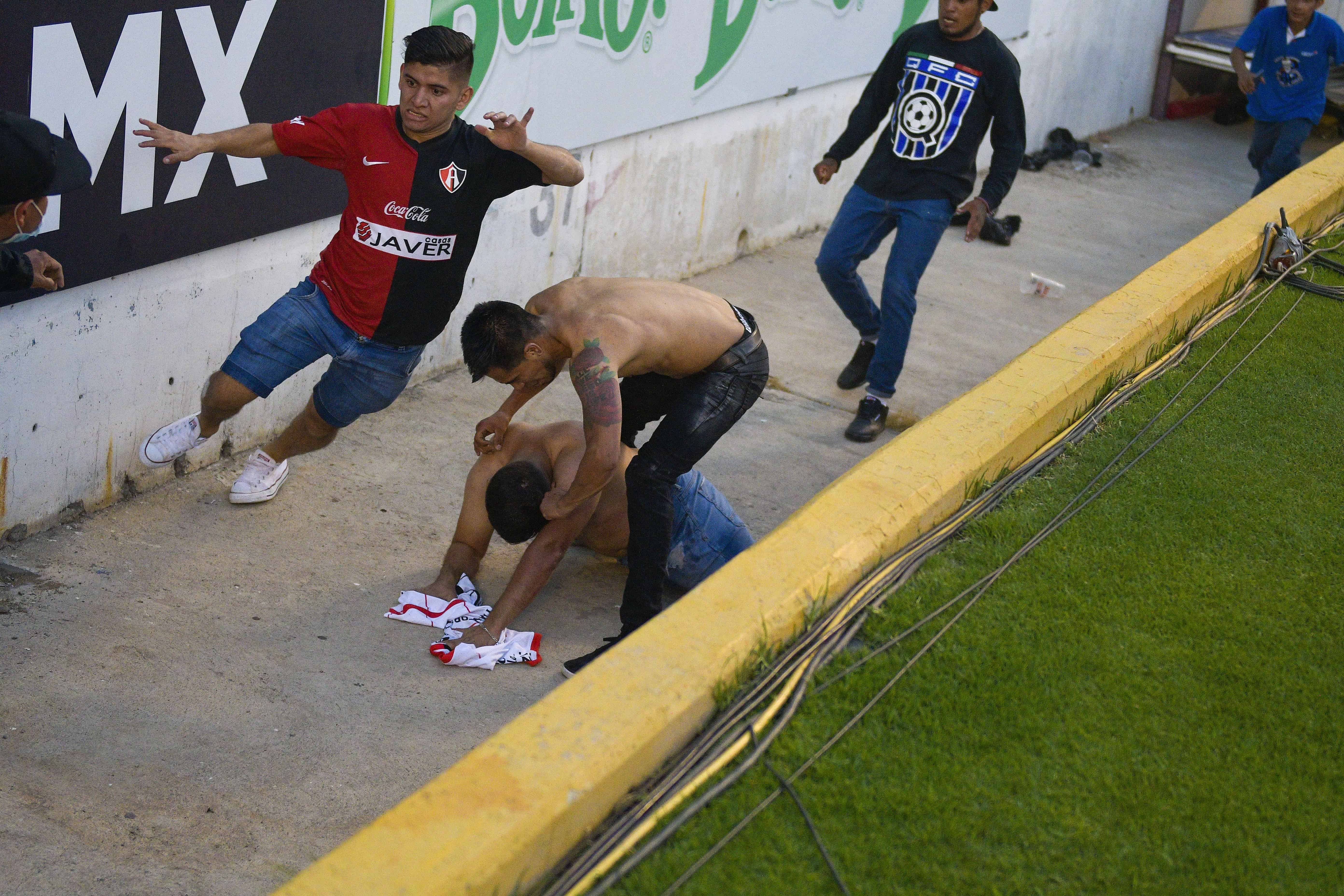 Aficionados del Querétaro y del Atlas riñen durante un partido de la Liga MX, el sábado 5 de marzo de 2022, en el Estadio Corregidora de Querétaro. 