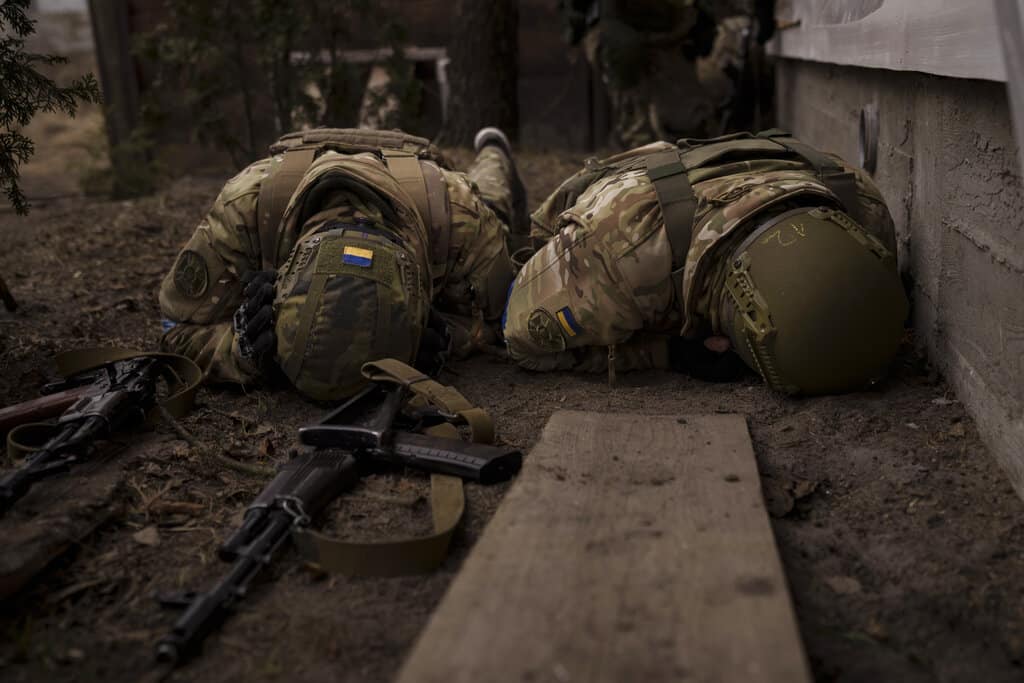 Soldados ucranianos se protegen del fuego de artillería en Irpin, en las afueras de Kiev, Ucrania, el domingo 13 de marzo de 2022.