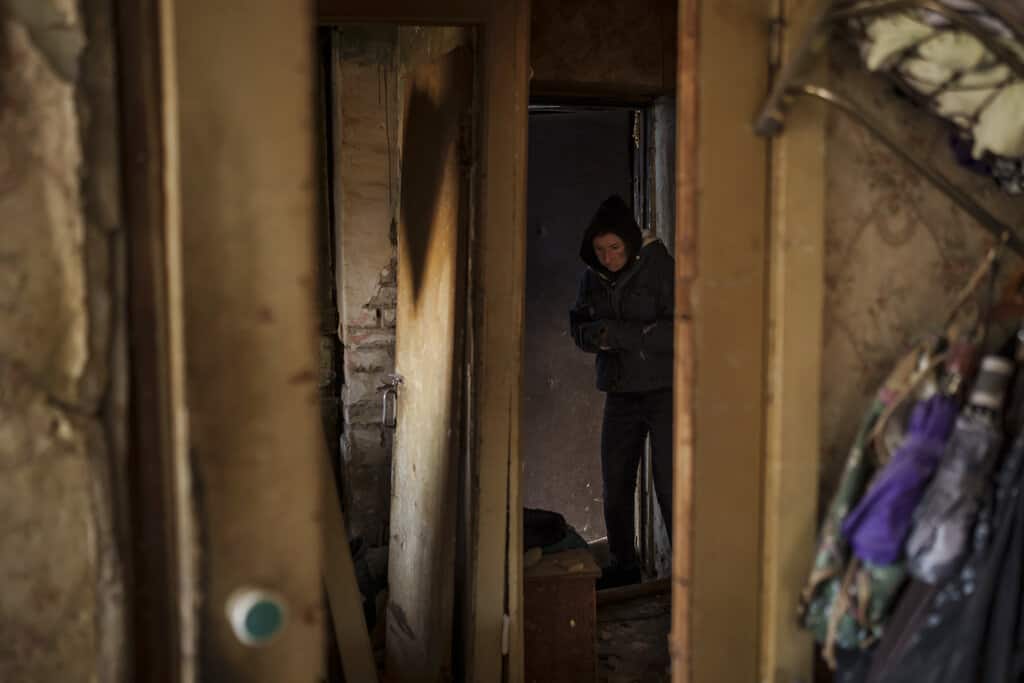 Una mujer camina dentro de su apartamento, gravemente dañado después de un bombardeo en Kiev, Ucrania, el viernes 18 de marzo de 2022. Las fuerzas rusas intensificaron su asalto a las ciudades ucranianas el viernes, con nuevos ataques con misiles y bombardeos en los bordes de la capital, Kiev, y la ciudad occidental. de Leópolis.