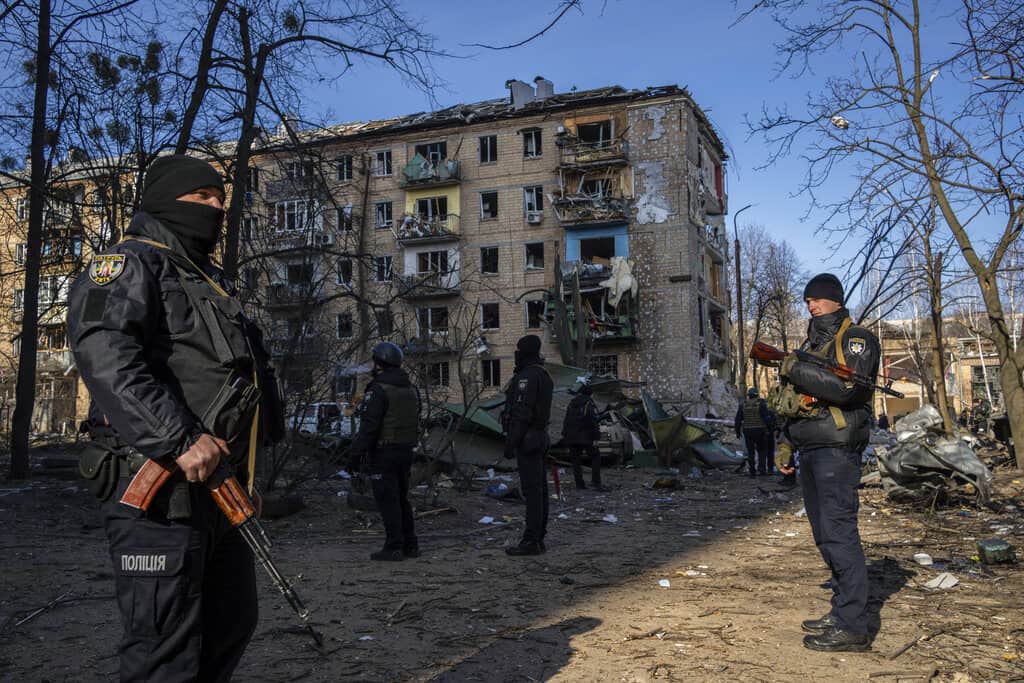 Policías montan guardia en el lugar donde un bombardeo dañó edificios residenciales en Kiev, Ucrania, el viernes 18 de marzo de 2022.