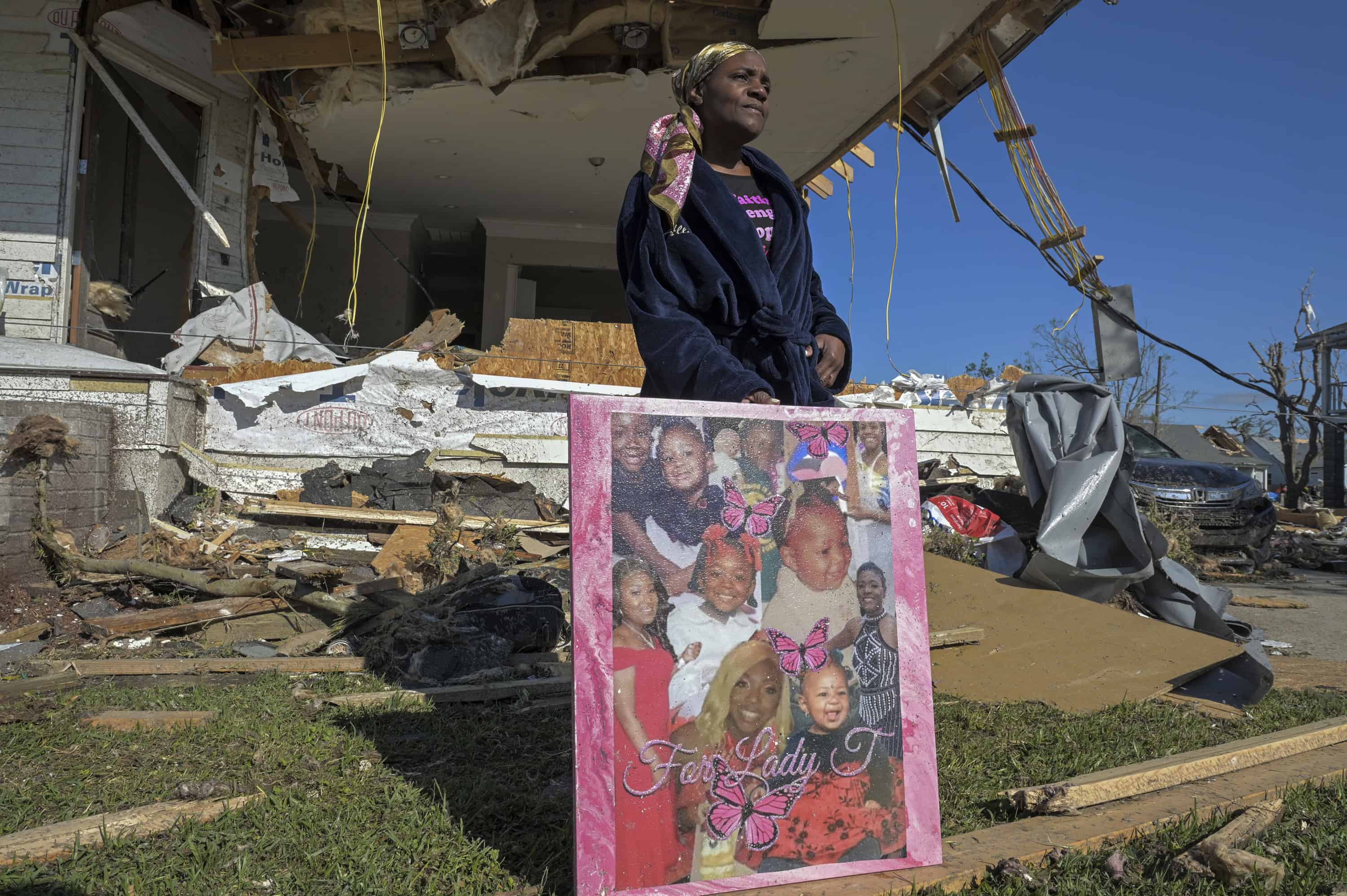 Taran Baker recupera un collage de fotos de sus dos hijas, Kamaria Clark y Quiney Wilson, de su casa dañada por un tornado en Rose Street la mañana después de que un tornado azotara Arabi, Luisiana, el miércoles 23 de marzo de 2022.