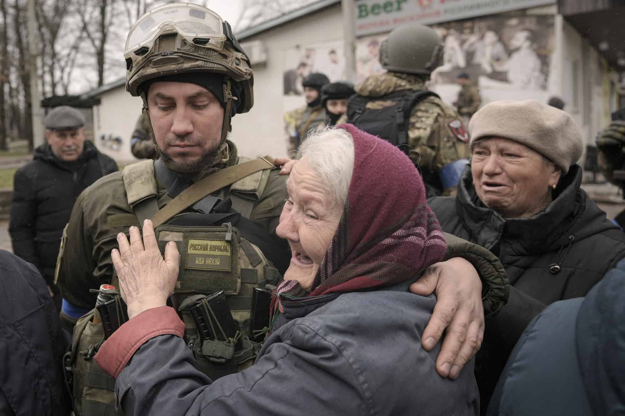 Una mujer abraza a un militar ucraniano después de que un convoy de vehículos militares y de ayuda llegara al suburbio de Bucha, Ucrania, anteriormente ocupado por Rusia, el sábado 2 de abril de 2022.