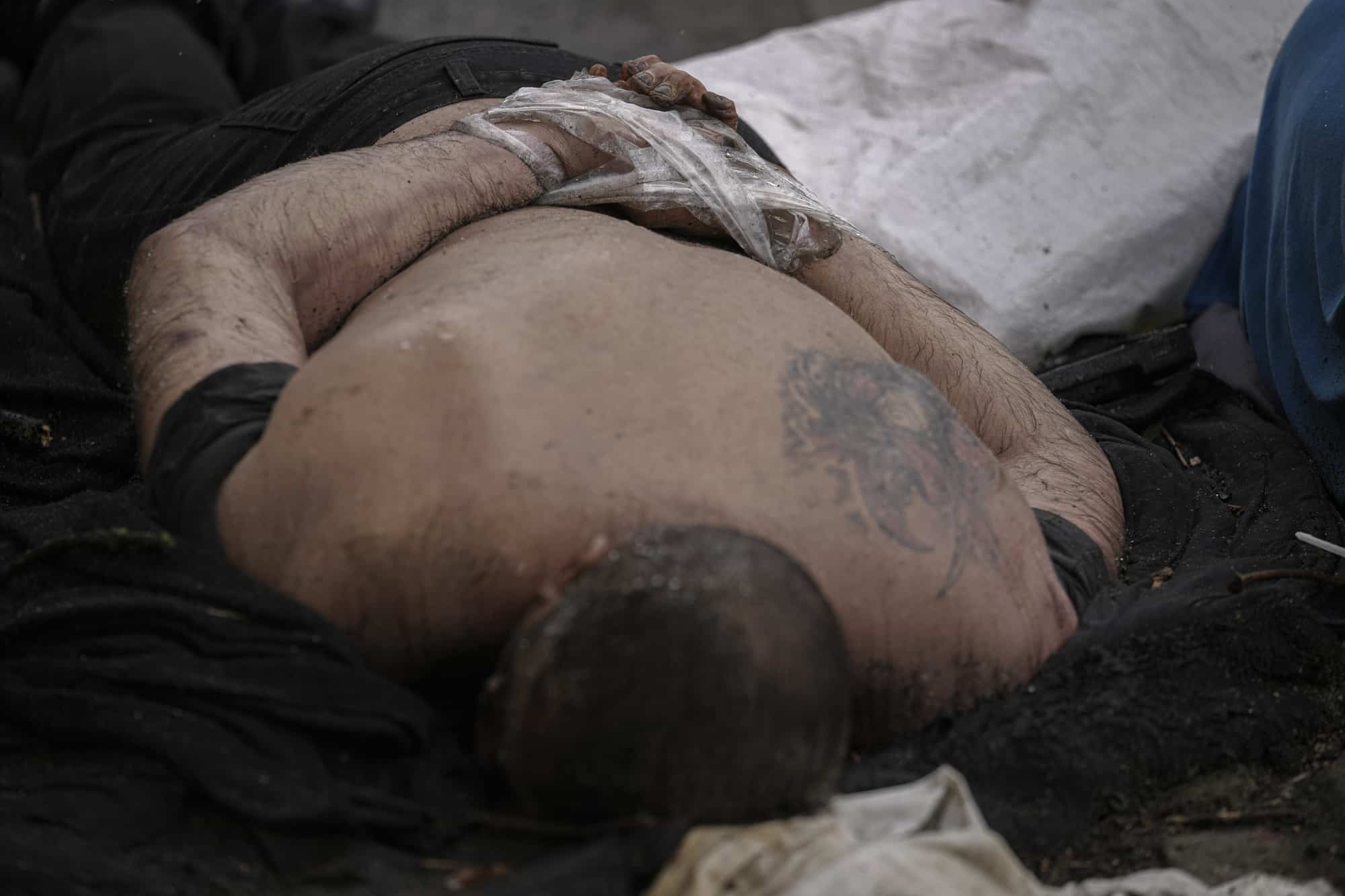 El cuerpo sin vida de un hombre con las manos atadas a la espalda yace en el pavimento en Bucha, Ucrania, el domingo 3 de abril de 2022.