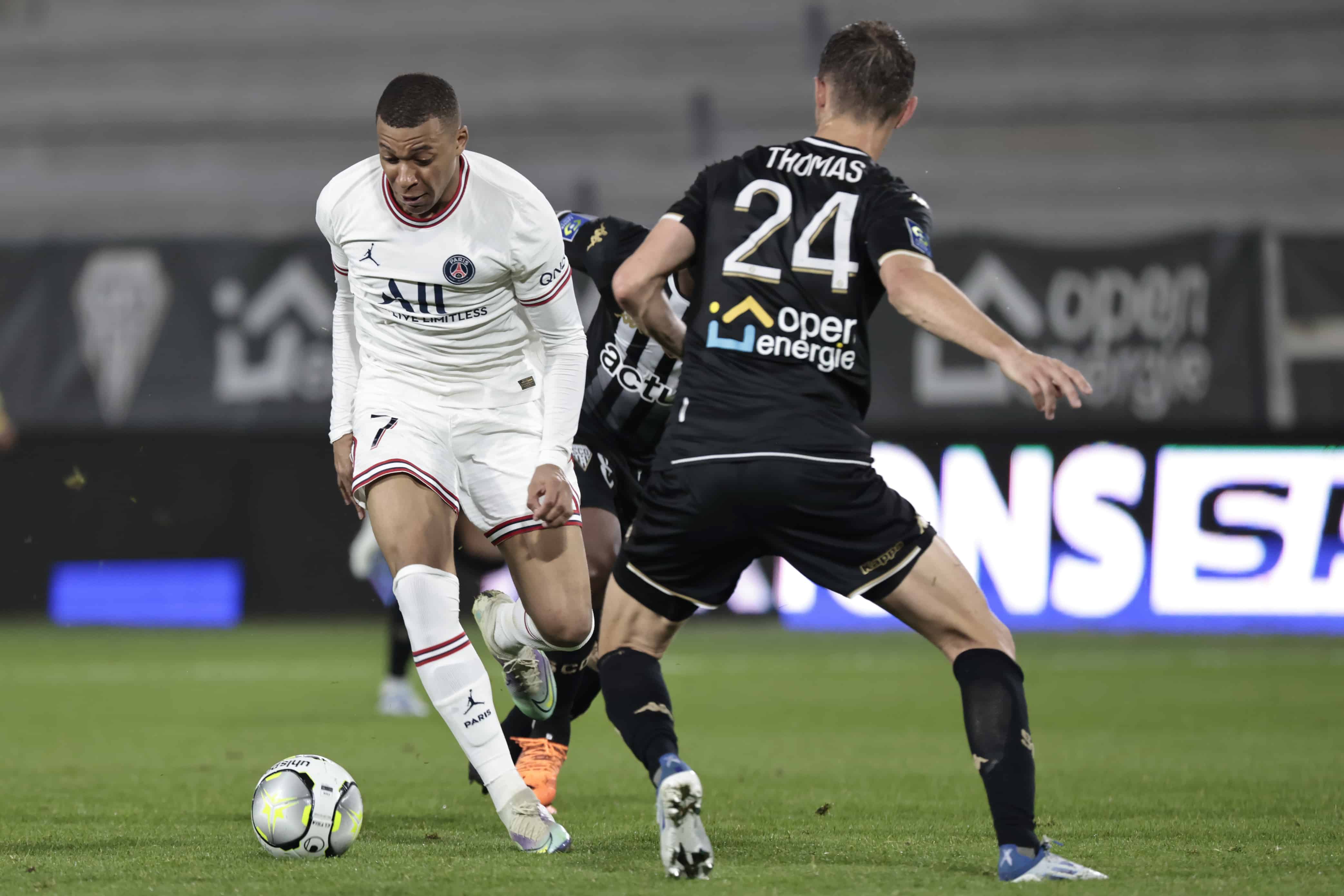 Kylian Mbappe del PSG, a la izquierda, lucha con Romain Thomas del Angers durante el partido de fútbol de la Liga Uno entre el Angers y el Paris Saint Germain, en el estadio Raymond-Kopa en Angers, oeste de Francia, el miércoles 20 de abril de 2022.