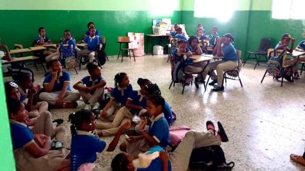 Por falta de butacas los estudiantes toman clases en el suelo