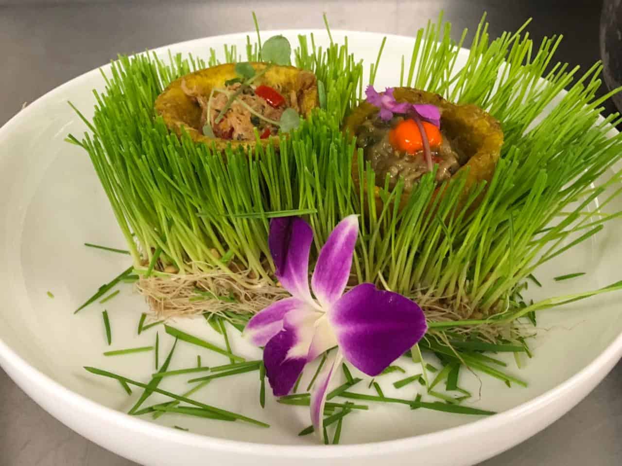 Nuestro amouse bouche: dúo de canastas de plátano rellenas de cangrejo guisado y berenjenas guisadas.