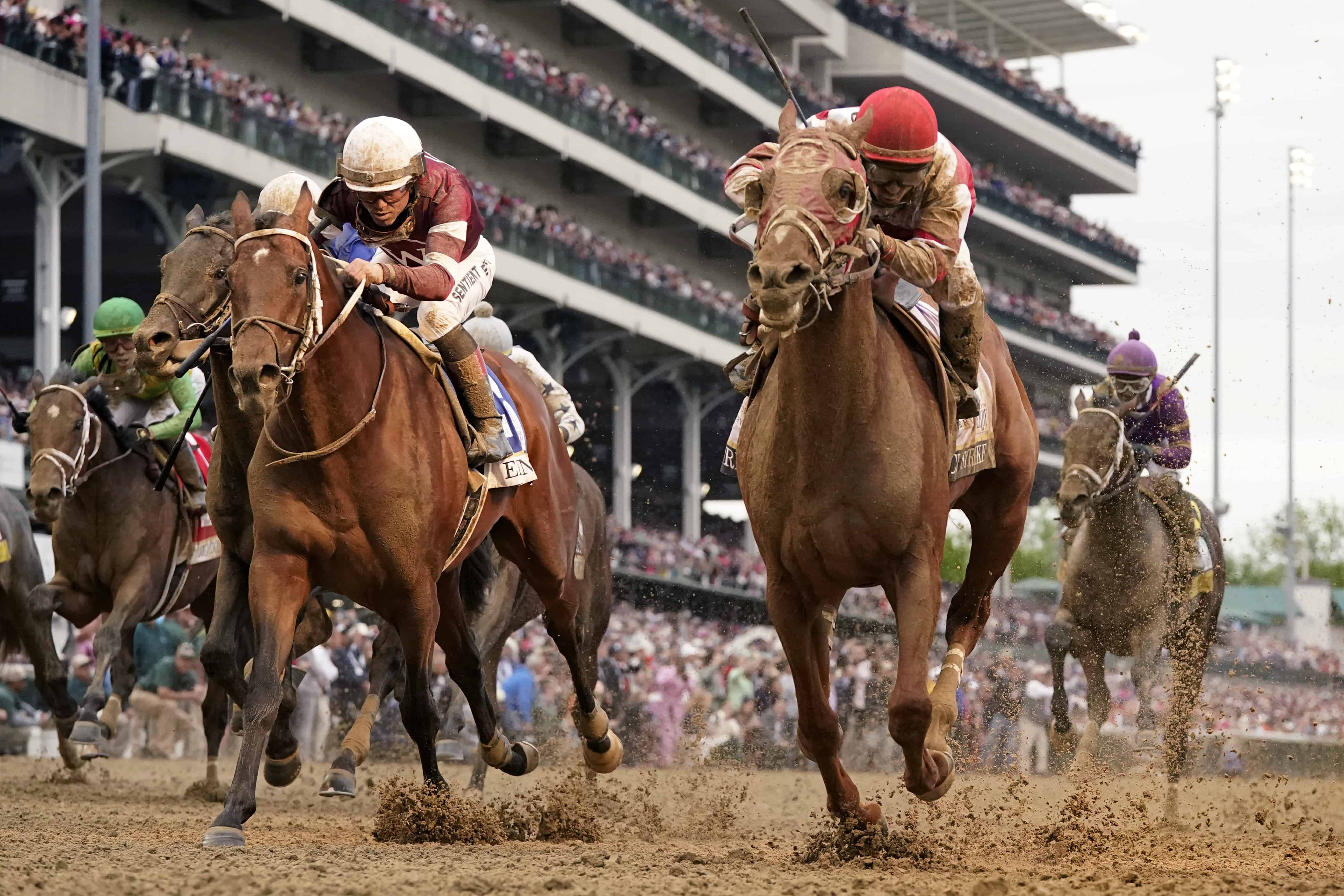 Sonny Leon monta a Rich Strike, centro, a través de la línea de meta para ganar la carrera número 148 de la carrera de caballos Derby de Kentucky en Churchill Downs el sábado 7 de mayo de 2022 en Louisville, Ky.