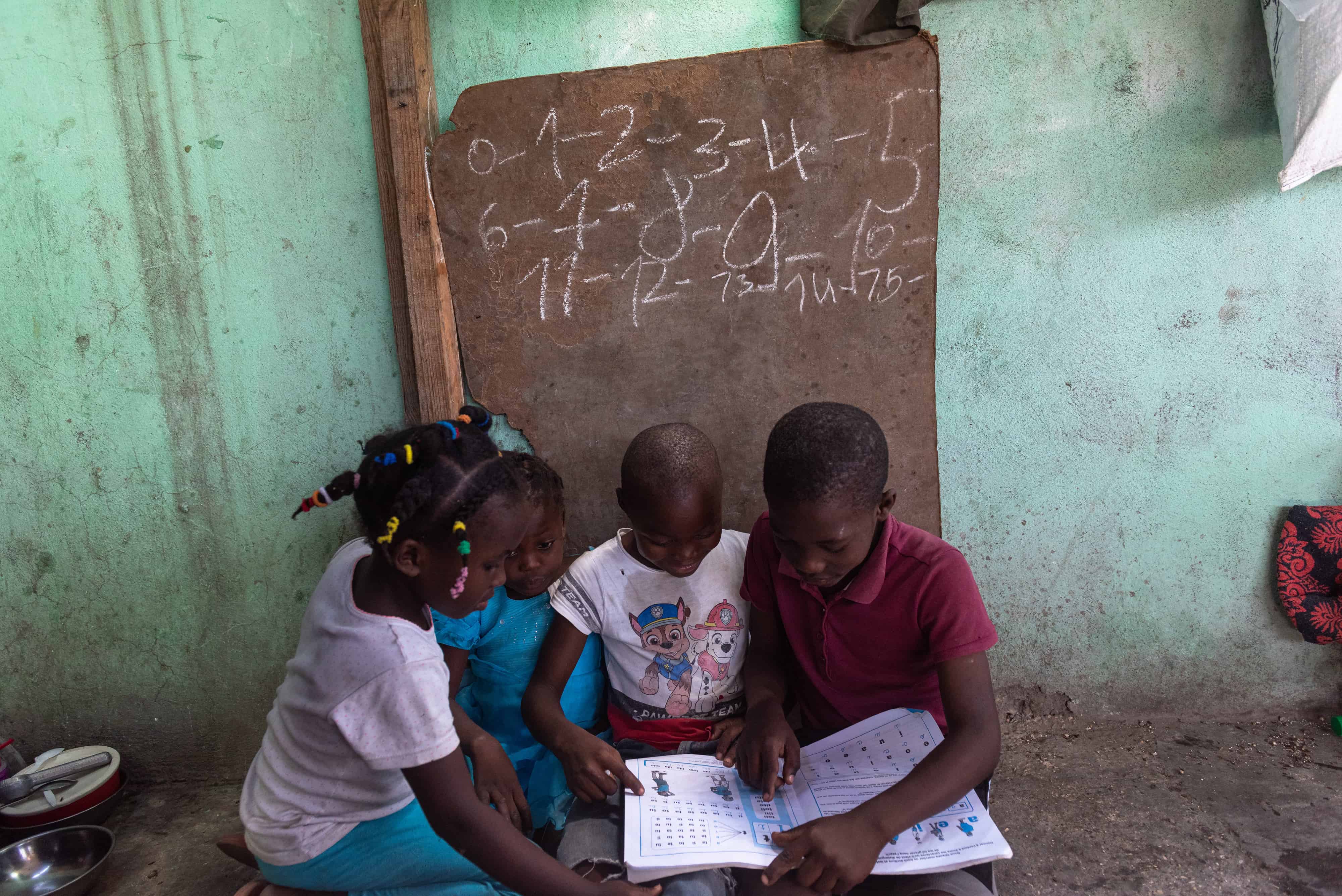  Niños le enseñan hoy a niños de menor edad en un albergue de desplazados internos por la guerra de pandillas, en la comuna de Tabarre, distrito de Puerto Príncipe (Haití). 