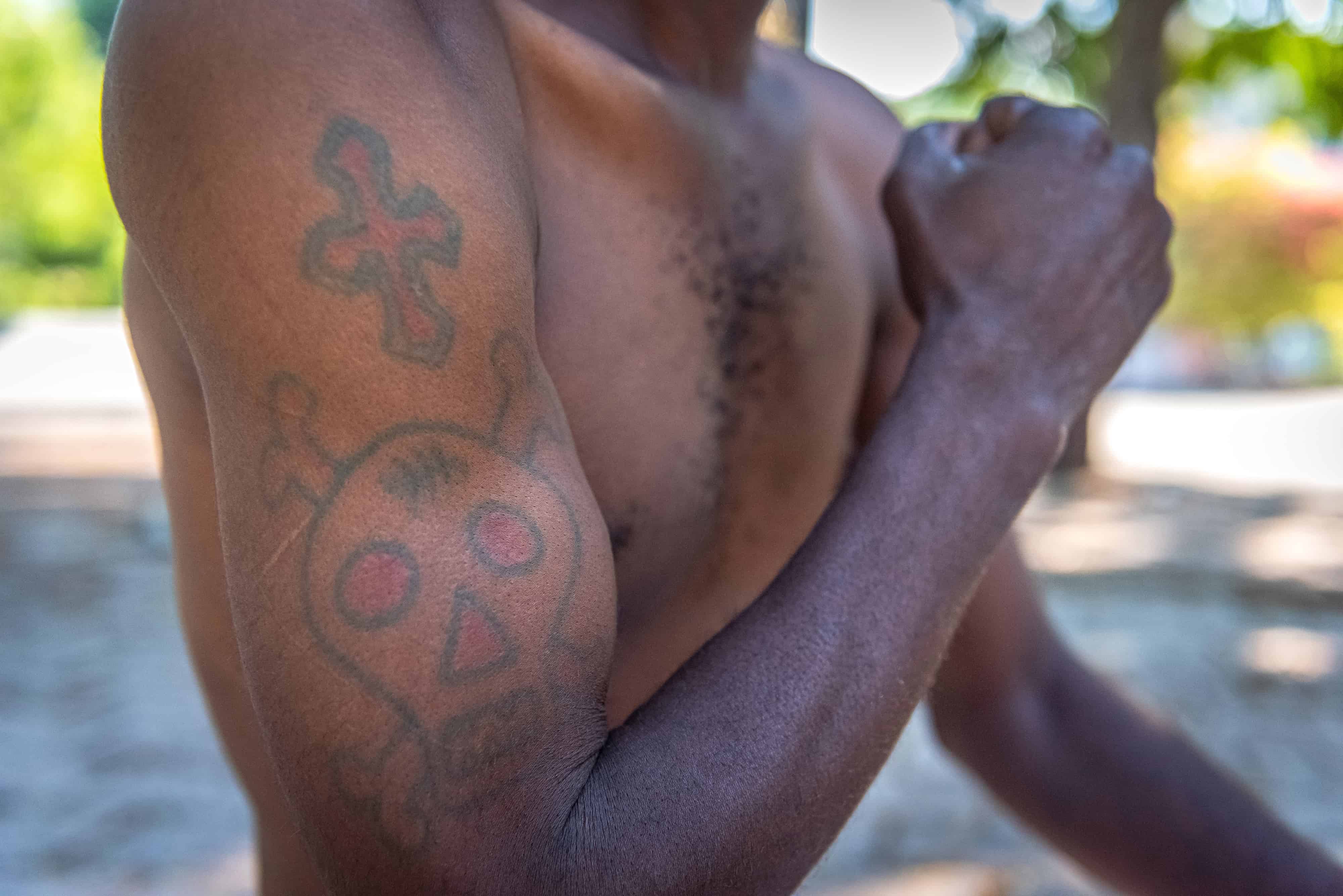Joseph Pierre, que creció y vive en la calle, dice estar orgulloso de mostrar su tatuaje de calavera y tibias cruzadas en su brazo, el 27 de mayo de 2022, en Puerto Príncipe (Haití). 