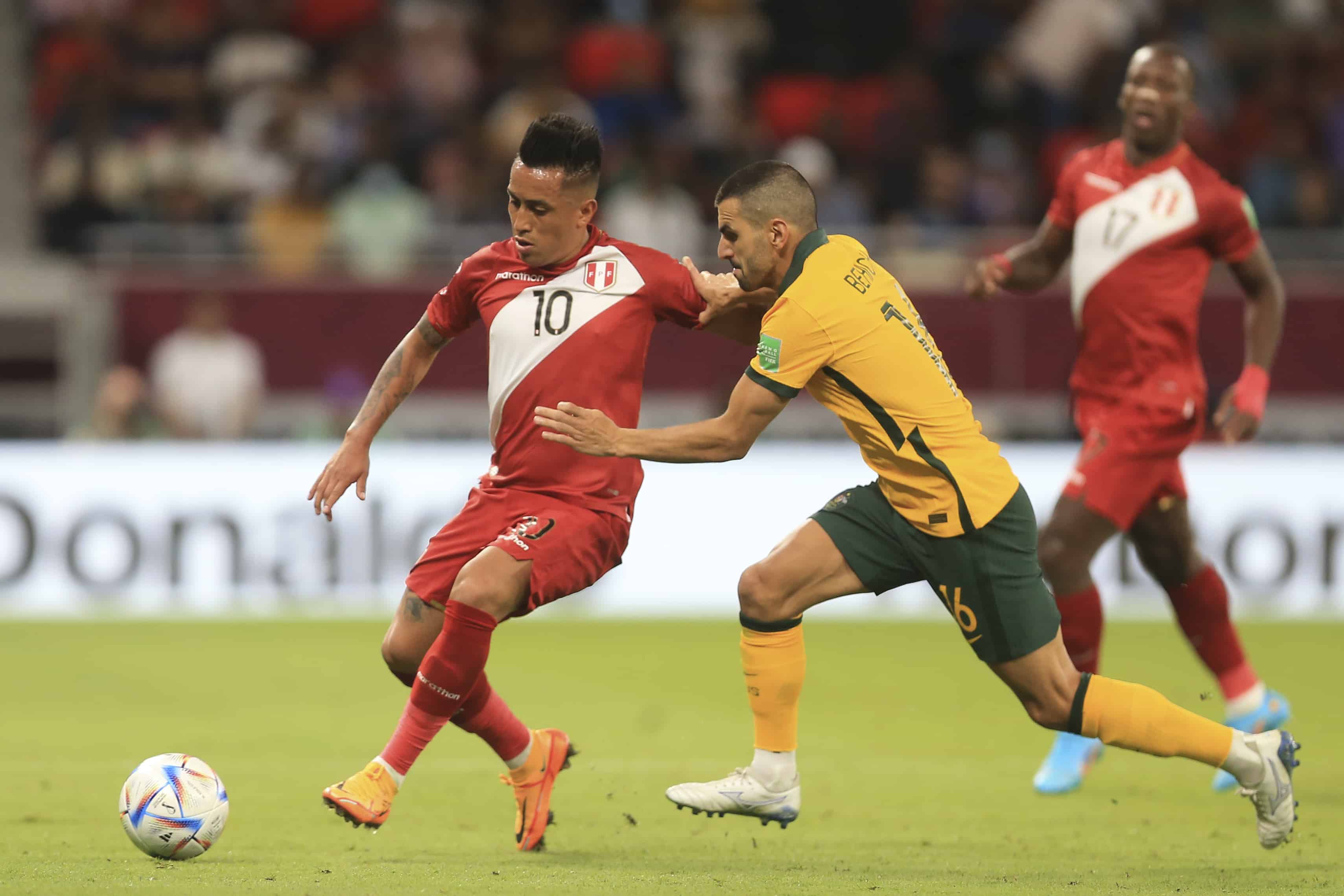 El peruano Christian Cueva (izquierda) y el australiano Aziz Behich pugnan por el balón en el repechaje intercontinental por una plaza a la Copa Mundial, en Al Rayyan, Qatar, el lunes 13 de junio de 2022.