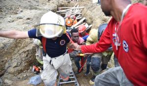 Rescatan dos de tres obreros atrapados por deslizamiento de tierra en Santiago