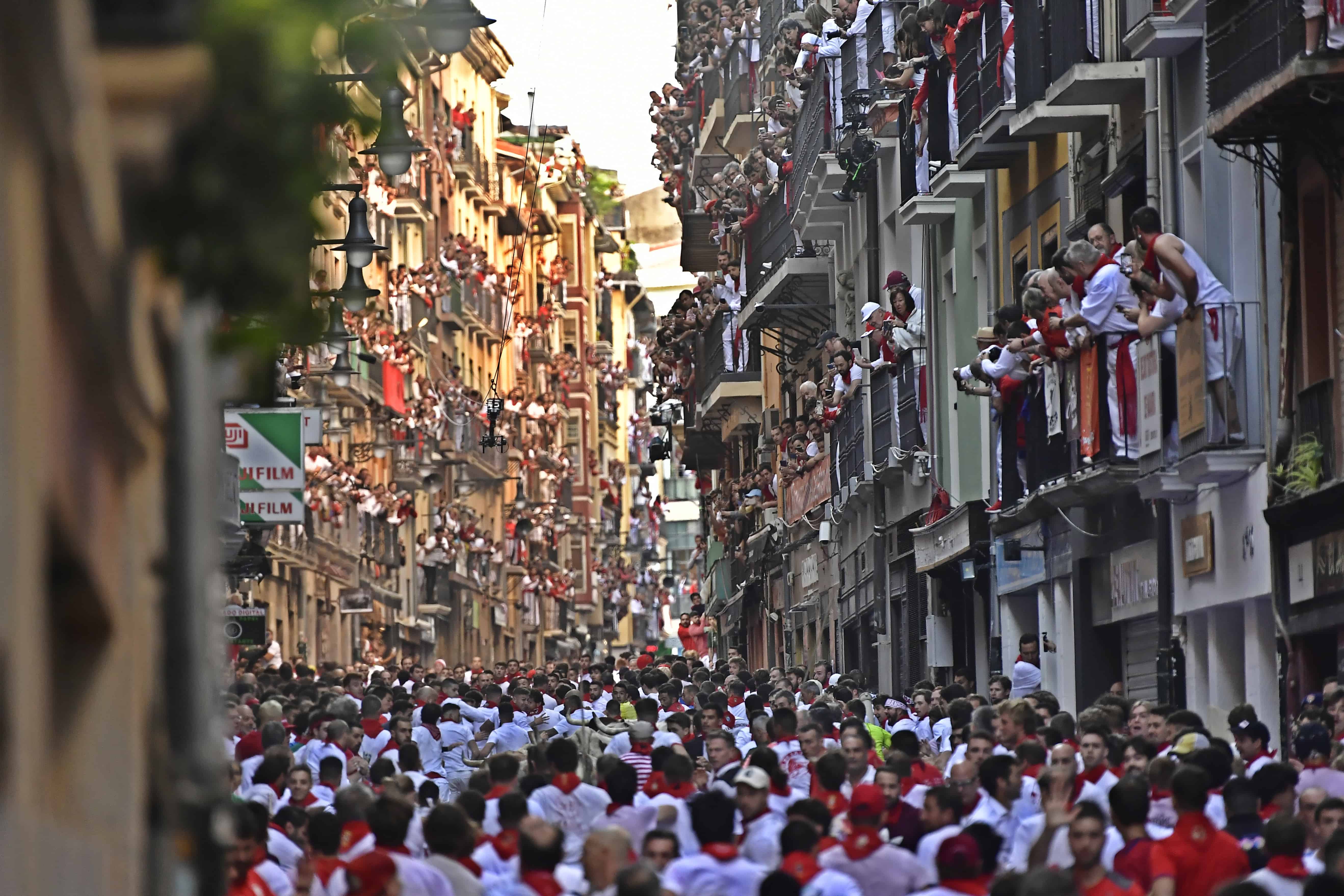 Sanfermines corriendo por la calle por delante de los toros bravos en el primer día de encierros en las fiestas de San Fermín, Pamplona, en el norte de España, el jueves 7 de julio de 2022.