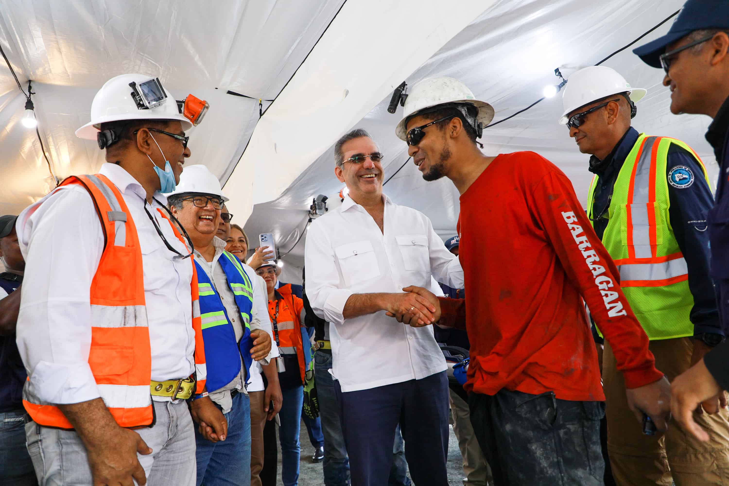 El presidente Luis Abinader estrecha la mano de Gregores Alexander Méndez, antes del chequeo médico de rigor, tras permanecer atrapado por diez días en una mina del Cerro de Maimón