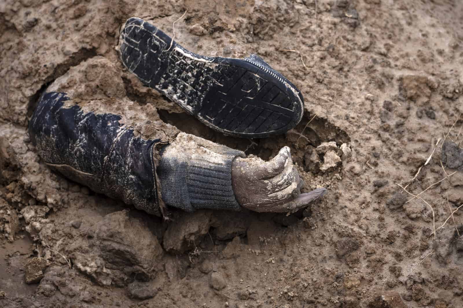 ARCHIVO - La mano de un cadáver emerge de una fosa común en Bucha, en las afueras de Kiev, Ucrania, el 4 de abril de 2022.