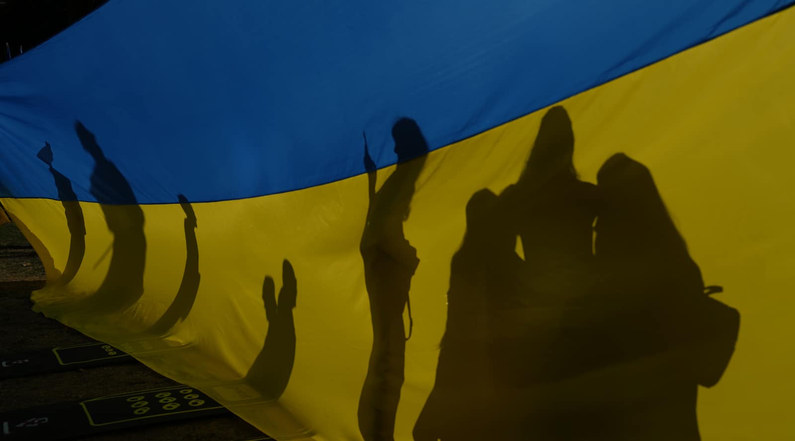 Una familia posa para una fotografía frente a una gran bandera ucraniana durante una manifestación del Día de la Independencia de Ucrania frente a Downing Street en Londres, el miércoles 24 de agosto de 2022.