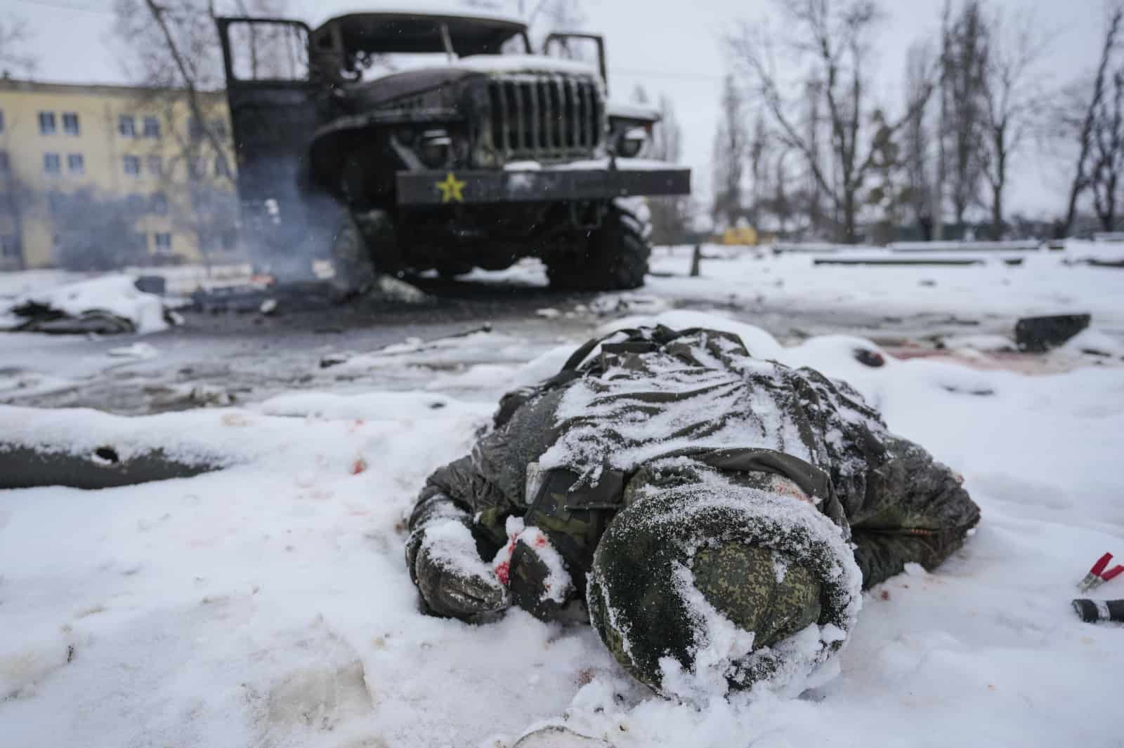 Archivo - El cadáver de un militar ruso yace boca abajo en la nieve junto a un destruido vehículo lanzacohetes del ejército ruso en las afueras de Járkiv, Ucrania, el 25 de febrero de 2022.