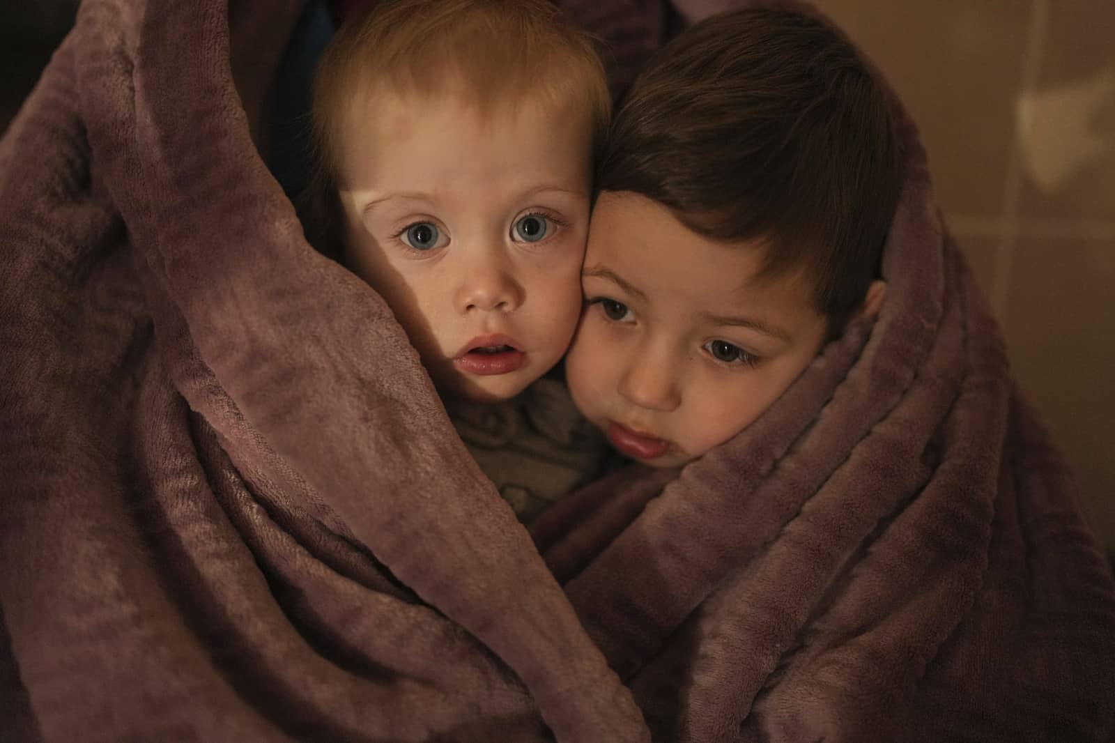 Archivo - Los hijos de los trabajadores médicos se calientan con una manta mientras esperan a sus familiares en un hospital de Mariúpol, Ucrania, el 4 de marzo de 2022.
