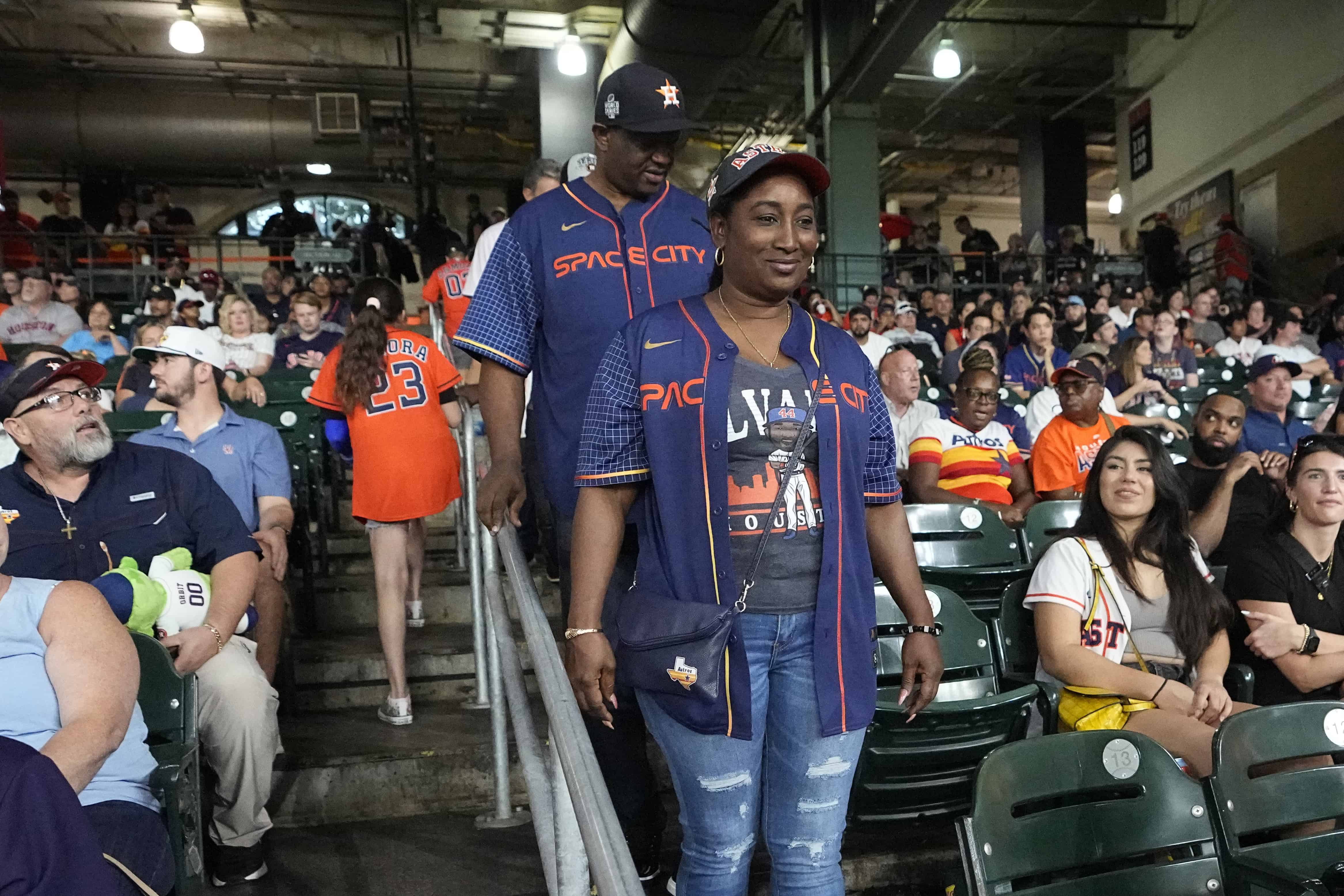 Los padres de Yordan Alvarez de los Astros de Houston, Agustín Eduardo Álvarez Salazar, trasero, y Mailyn Cadogan Reyes caminan hacia sus asientos para ver a los Mellizos de Minnesota y los Astros de Houston.