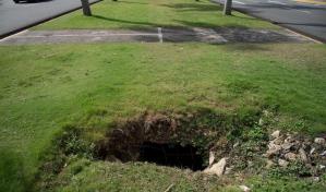 Hoyos en la isleta de la calle Enrique Jiménez Moya, un peligro para transeúntes