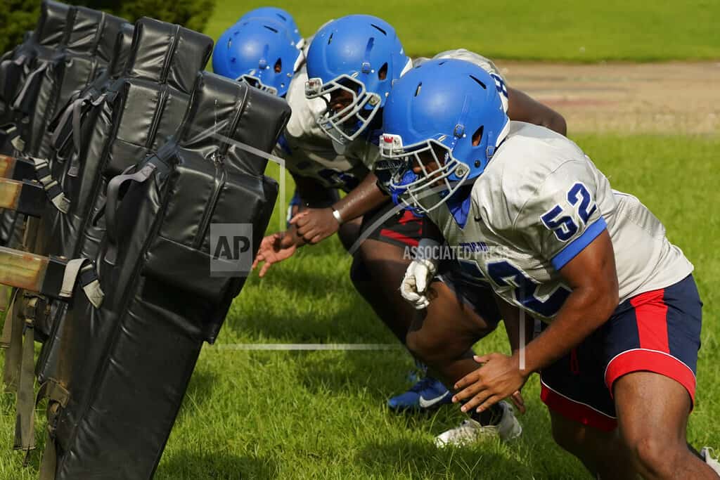 Los linieros ofensivos de fútbol americano de la Escuela Secundaria Murrah se enfrentan al trineo de bloqueo en una práctica, el miércoles 31 de agosto de 2022, en Jackson, Misisipi. y otros equipos que usan sus jugadores. La reciente inundación empeoró los antiguos problemas del sistema de agua de Jackson.&nbsp;
