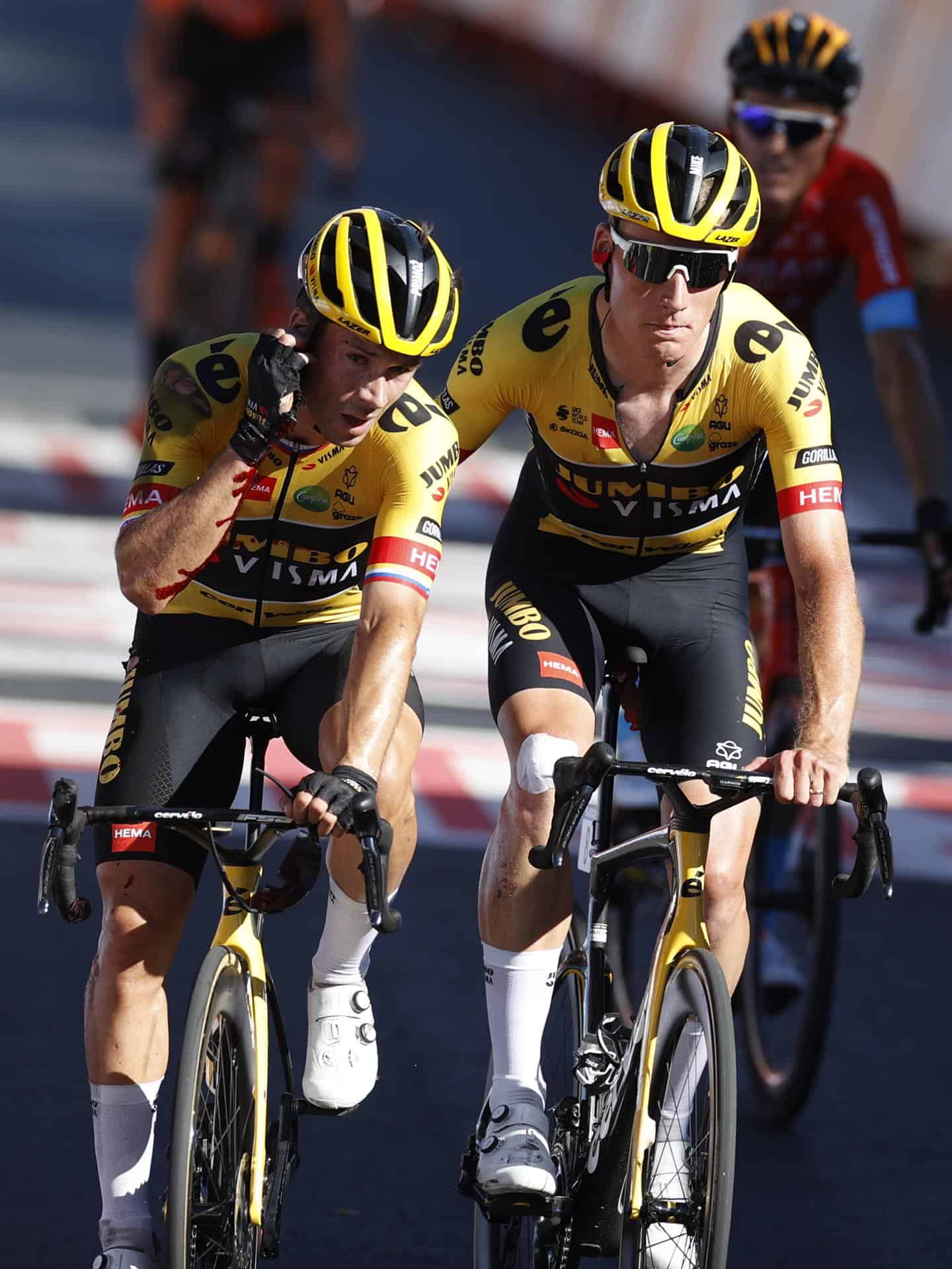 El ciclista esloveno Primoz Roglic (i), del equipo Jumbo Visma, llega a la línea de meta tras sufrir una caída a pocos metros de ésta, en la decimosexta etapa de la Vuelta a España, entre Sanlúcar de Barrameda y Tomares sobre 189,4 kilómetros, este martes.&nbsp;