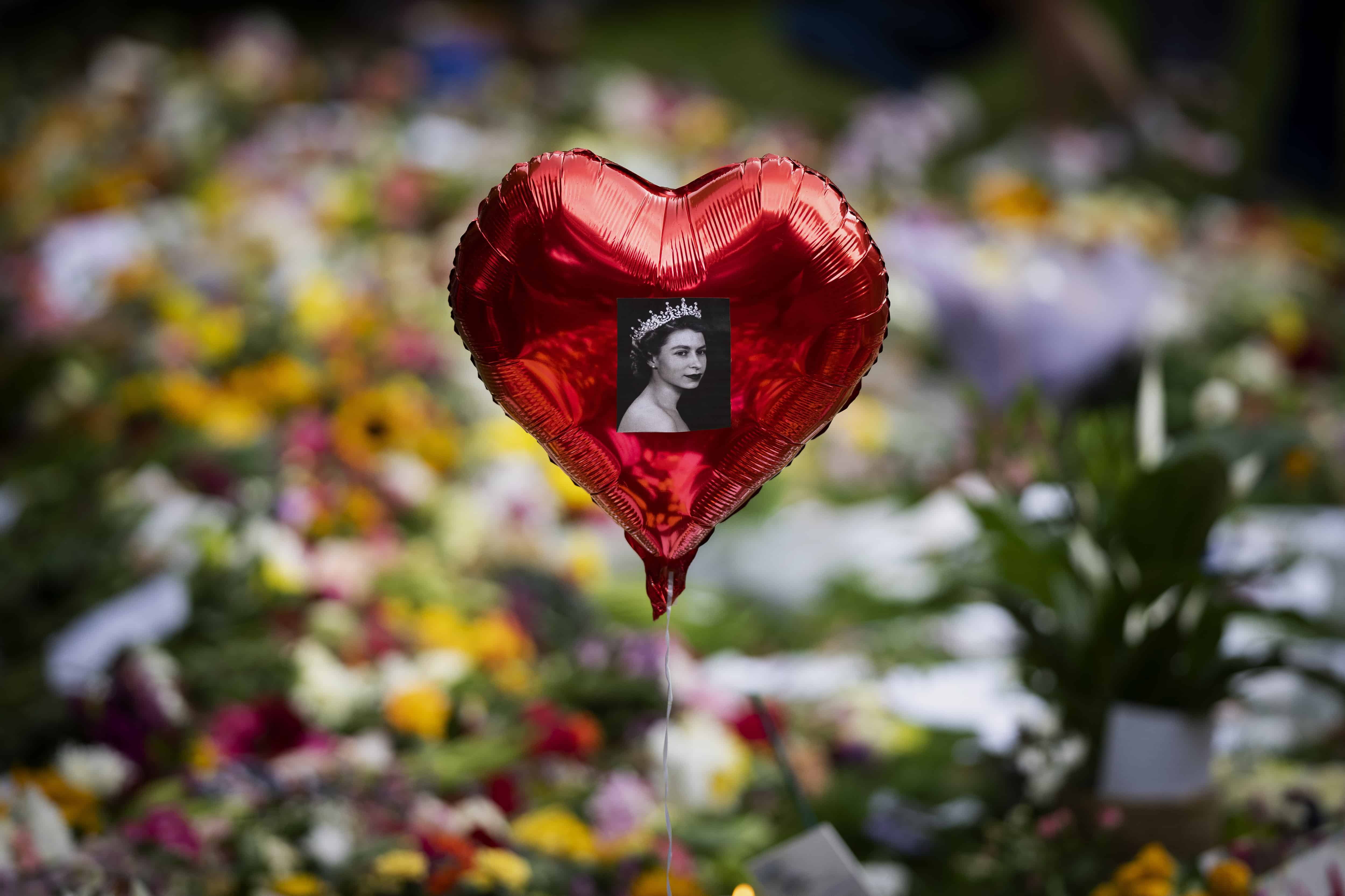 Un globo con una imagen de la reina Isabel II se cierne sobre las flores en el monumento conmemorativo de Green Park, cerca del Palacio de Buckingham, en Londres, el 1 de septiembre de 2019. 10 de febrero de 2022.