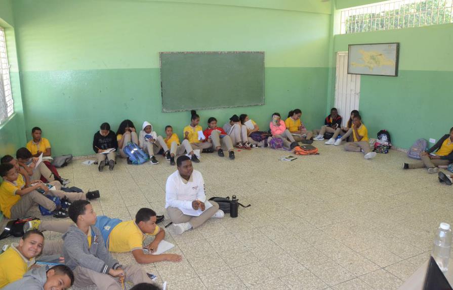 Estudiantes reciben docencia en el piso por falta de butacas en escuela de Santiago
