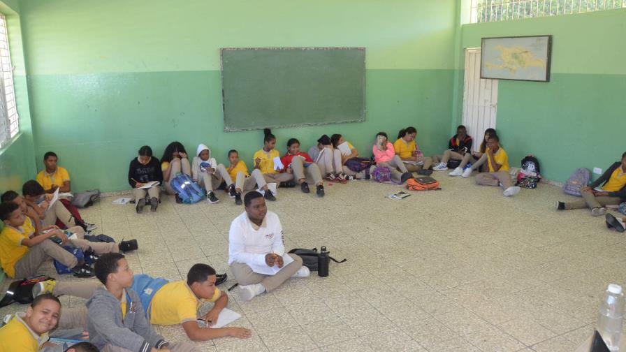 Estudiantes reciben docencia en el piso por falta de butacas en escuela de Santiago