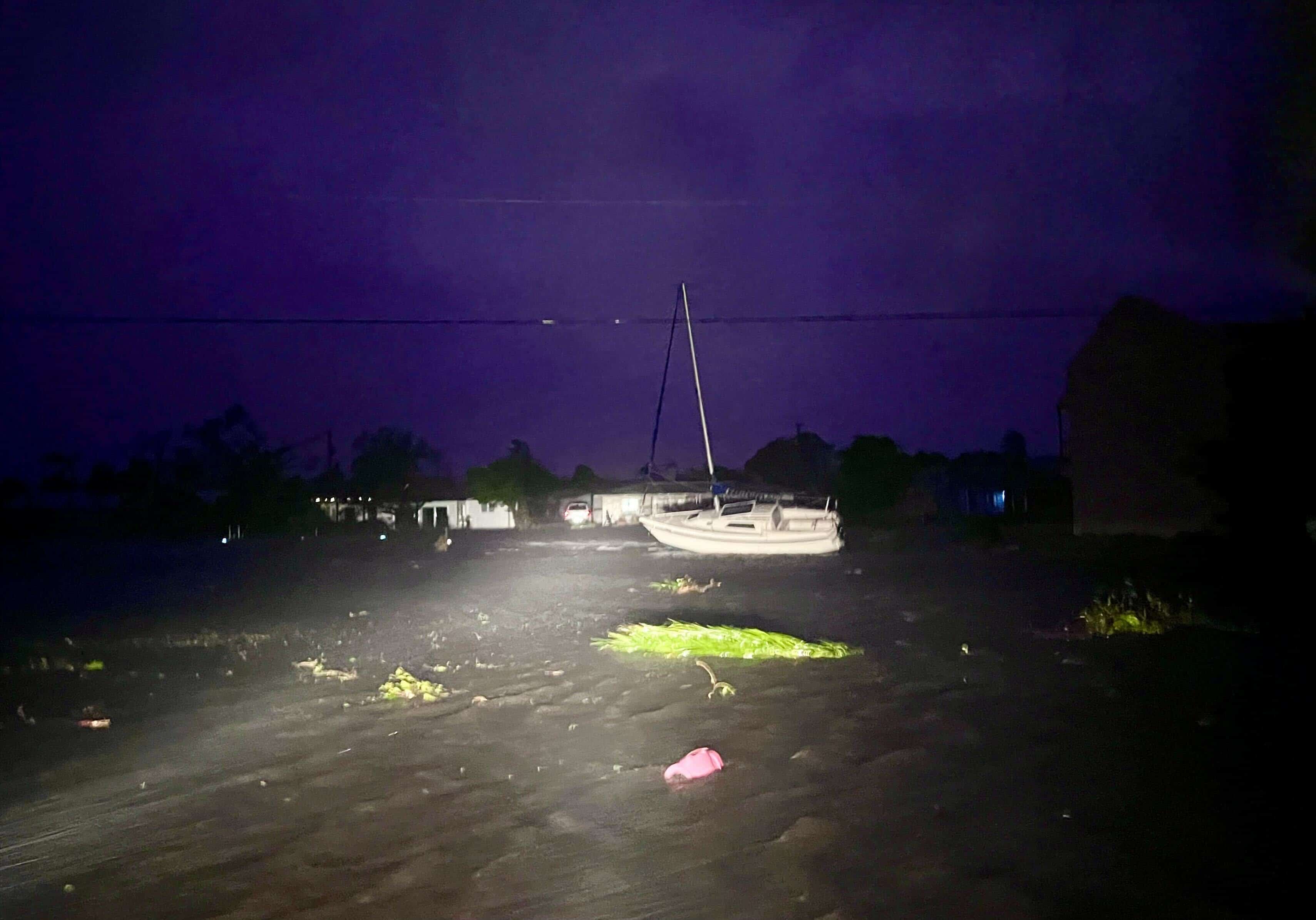 Un bote desplazado se encuentra junto a la carretera en la esquina sureste de Cape Coral el miércoles 28 de septiembre de 2022 por la noche, mientras los vientos del huracán Ian continúan azotando las calles empapadas.