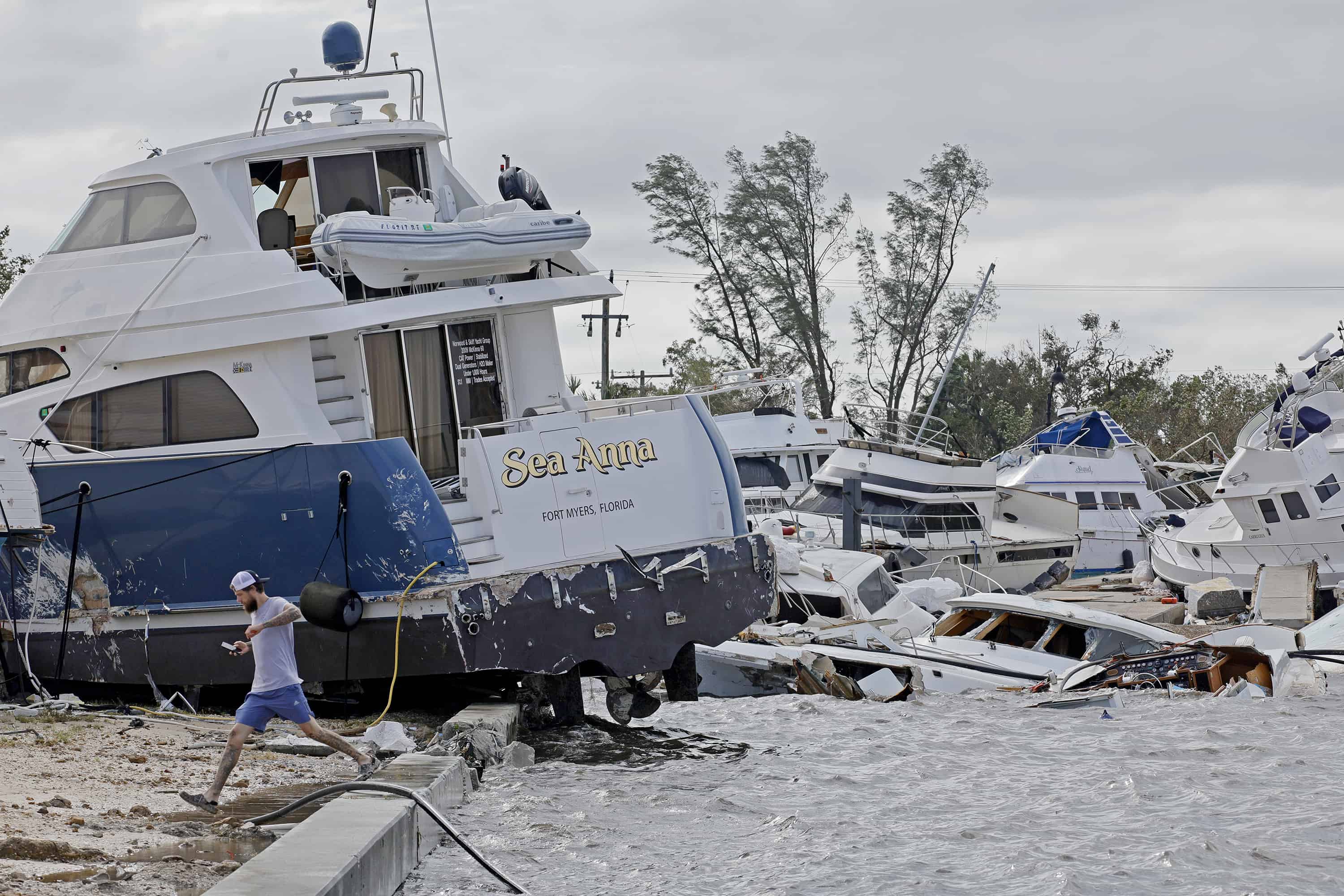 Joe Dalton, de vacaciones desde Cleveland, Ohio, revisa los botes varados en Fort Myers Wharf a lo largo del río Caloosahatchee el jueves 29 de septiembre de 2022 en Fort Myers, Florida, luego del huracán Ian.