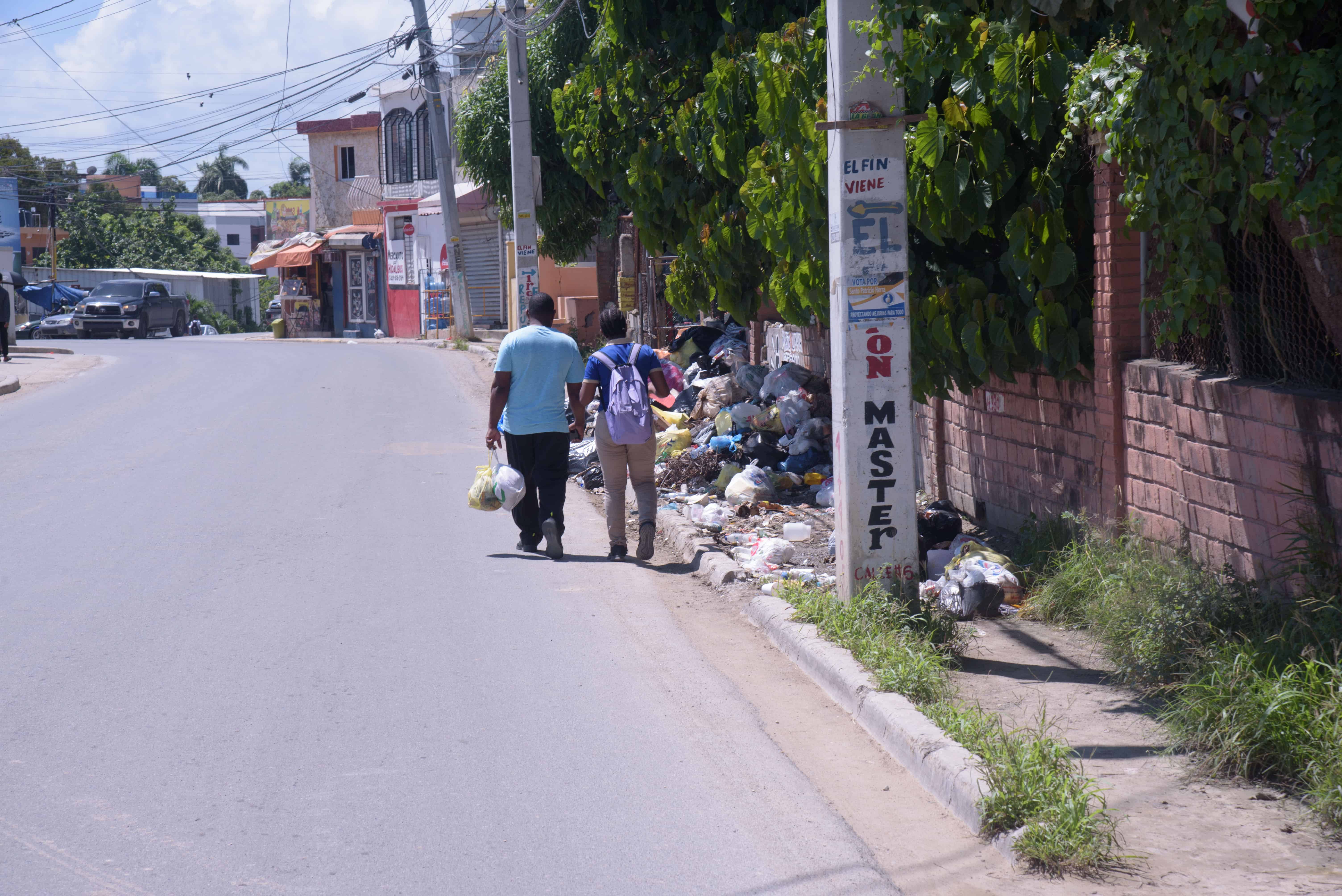 Esto en la carretera La Cienaga, Santo Domingo Oeste, la gente camina por la calle por la basura