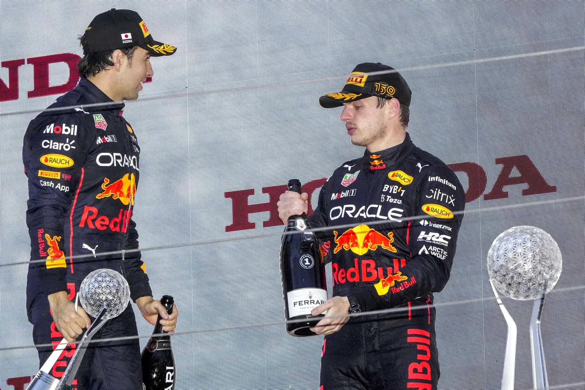  El piloto holandés de Fórmula Uno Max Verstappen de Red Bull Racing, ganador y campeón del mundo, conversa con su compañero y segundo clasificado, el piloto mexicano de Fórmula Uno Sergio Pérez (L) de Red Bull Racing al final de la Gran Premio de Fórmula Uno de Japón en el Suzuka International Racing Course, Suzuka, Japón, 09 de octubre de 2022.