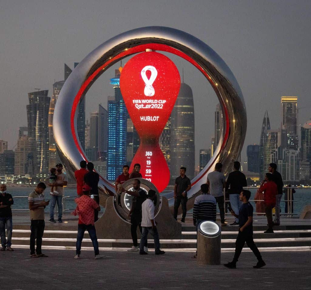 Un grupo de persona rodea el relojo con la cuenta agresiva de la Copa Mundial de 2022en Doha, Qatar, el 25 de noviembre de 2021.