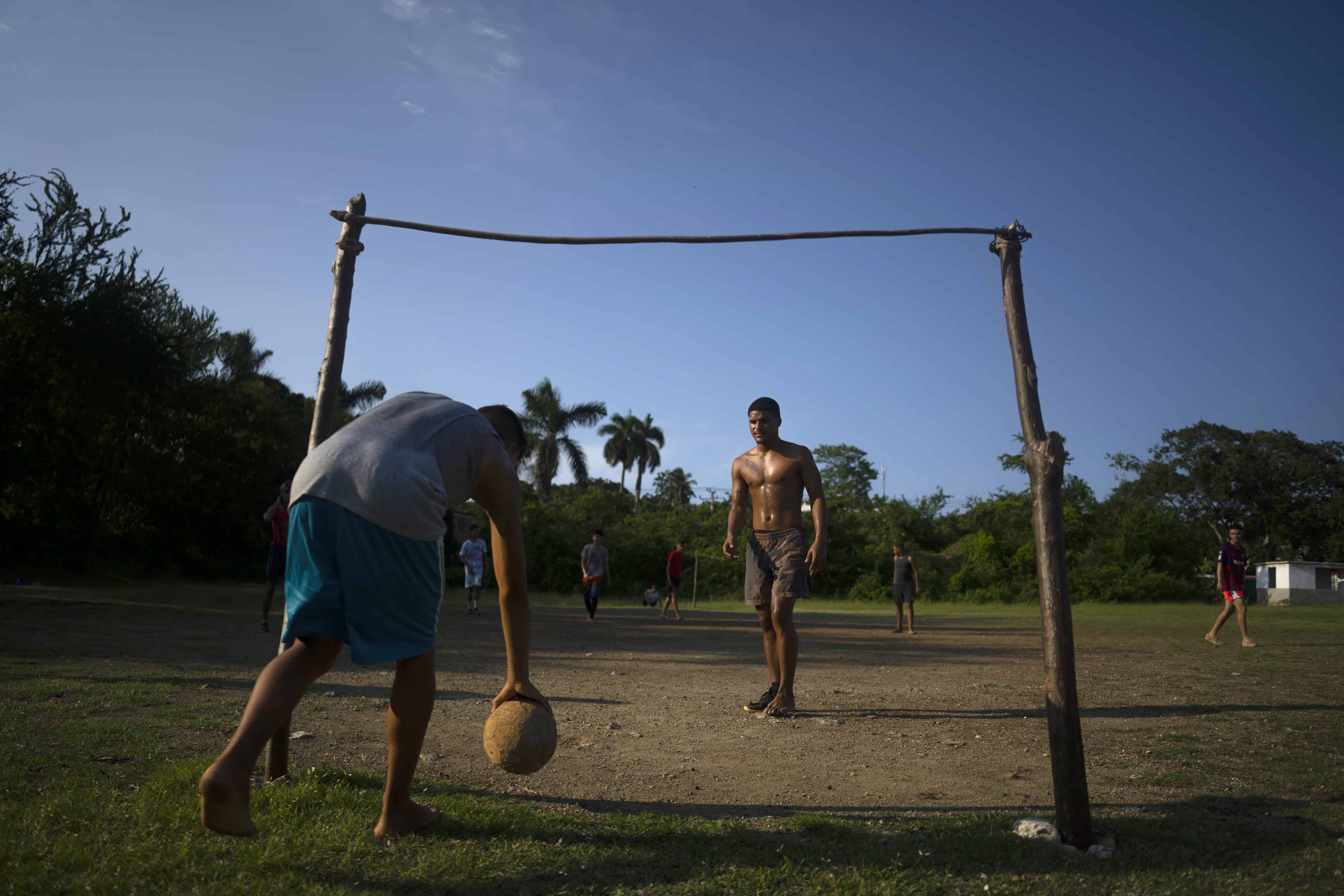 Un jugador recoge un balón durante un partido de fútbol en una precaria cancha de Guanabacoa (Cuba) el 15 de octubre del 2022.