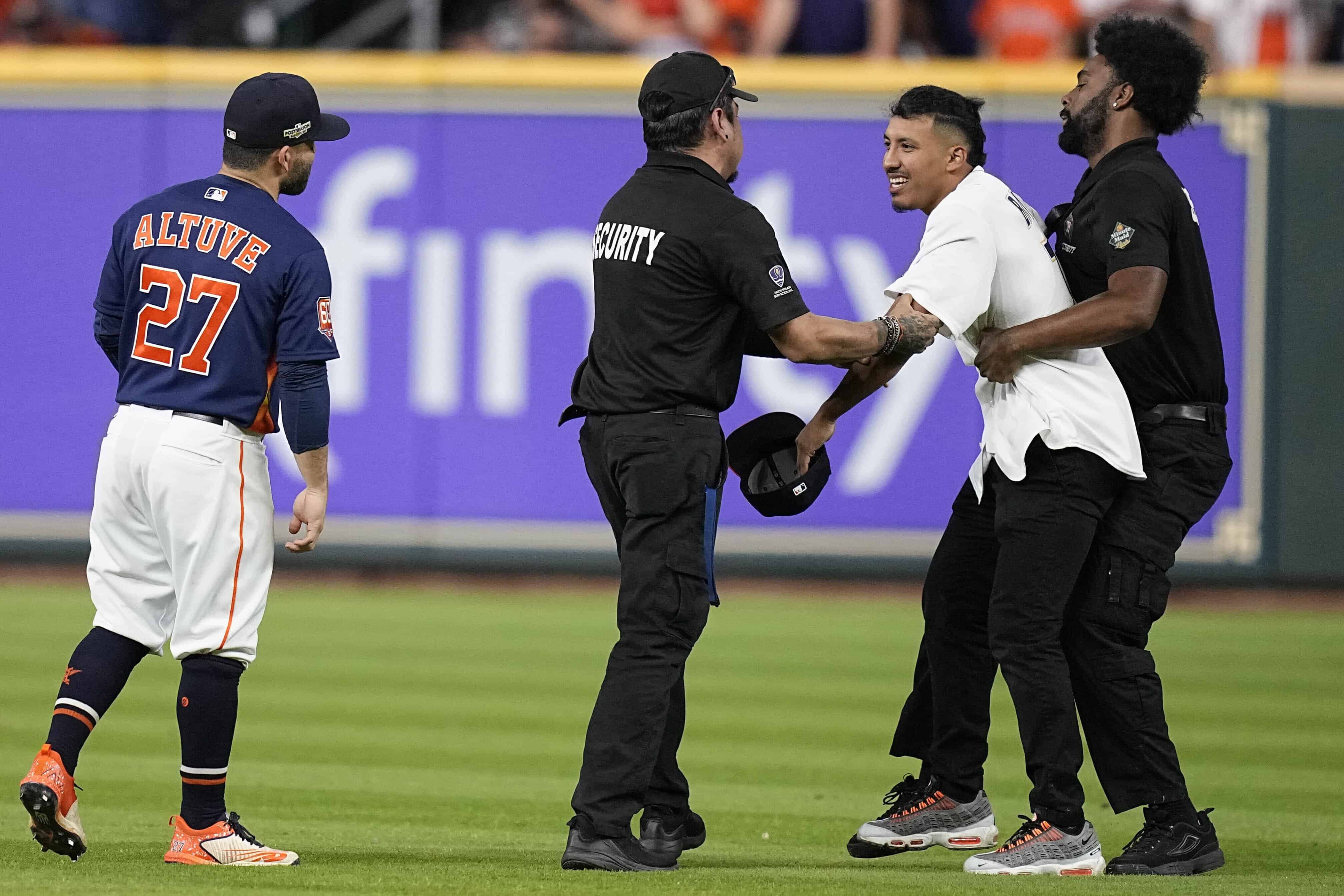 Personal de seguridad se lleva a un hombre que invadió el terreno y que habló con el venezolano José Altuve, de los Astros de Houston, el jueves 20 de octubre de 2022, durante el segundo juego de la Serie de Campeonato de la Liga Americana ante los Yanquis de Nueva York.