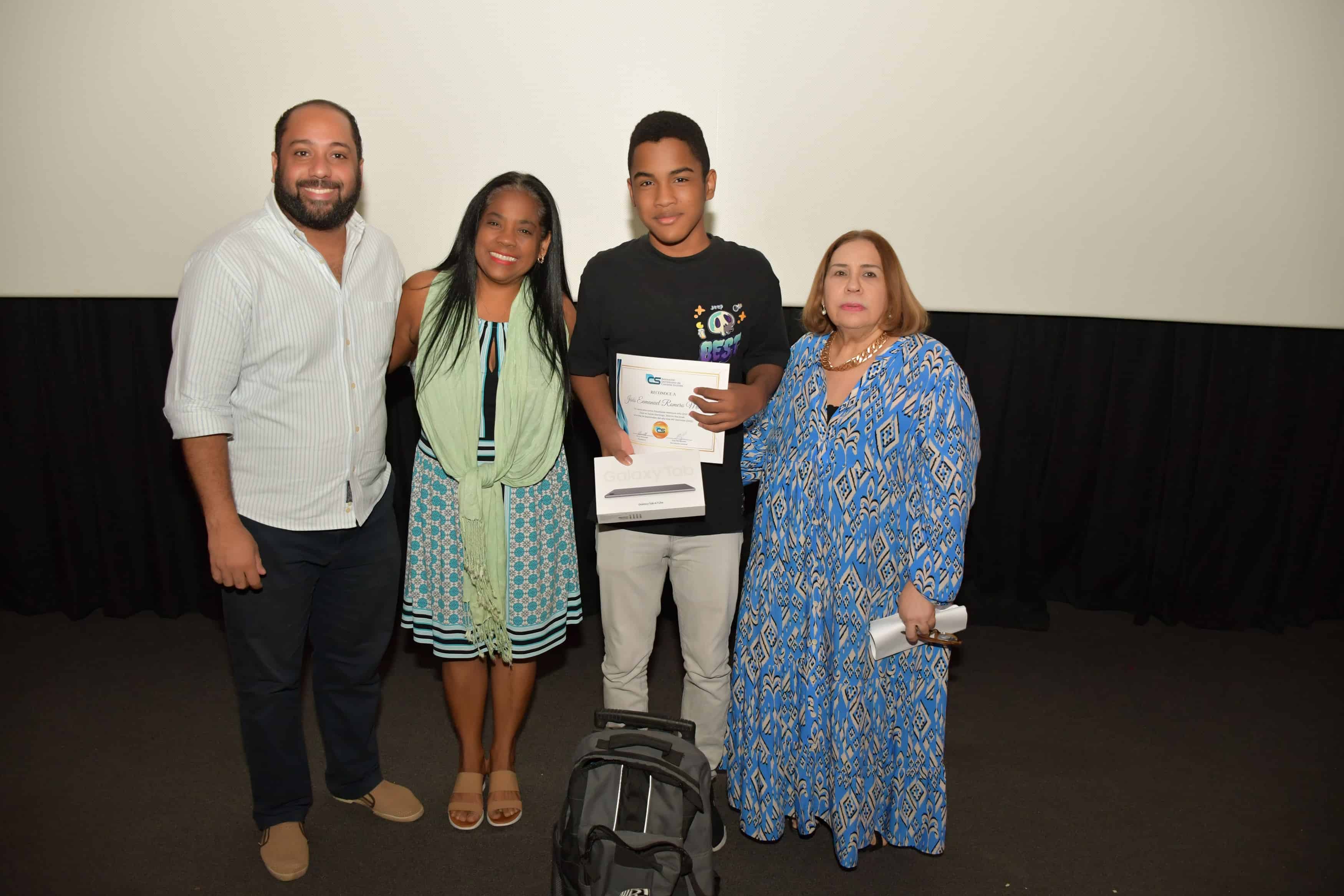 Orlando Jerez, Miguelina Santos, el nin~o Enmanuel Romero Mieses, quien recibe como premio una tablet, y Mirna Pimentel.