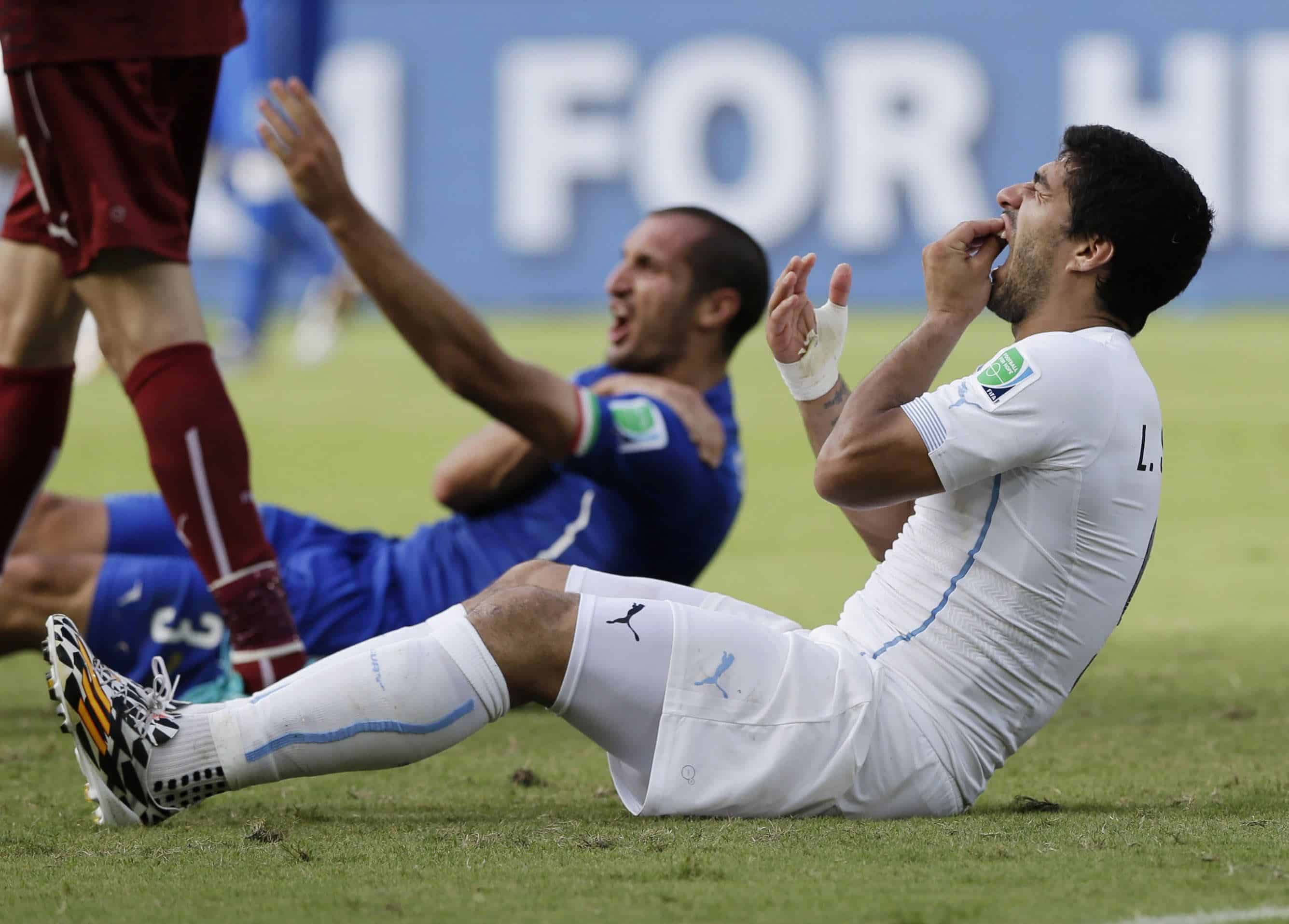 El uruguayo Luis Suárez se sujeta los dientes después de chocar con el hombro del italiano Giorgio Chiellini durante el partido del grupo D de la Copa Mundial de fútbol entre Italia y Uruguay en el Arena das Dunas en Natal, Brasil, el 24 de junio de 2014.